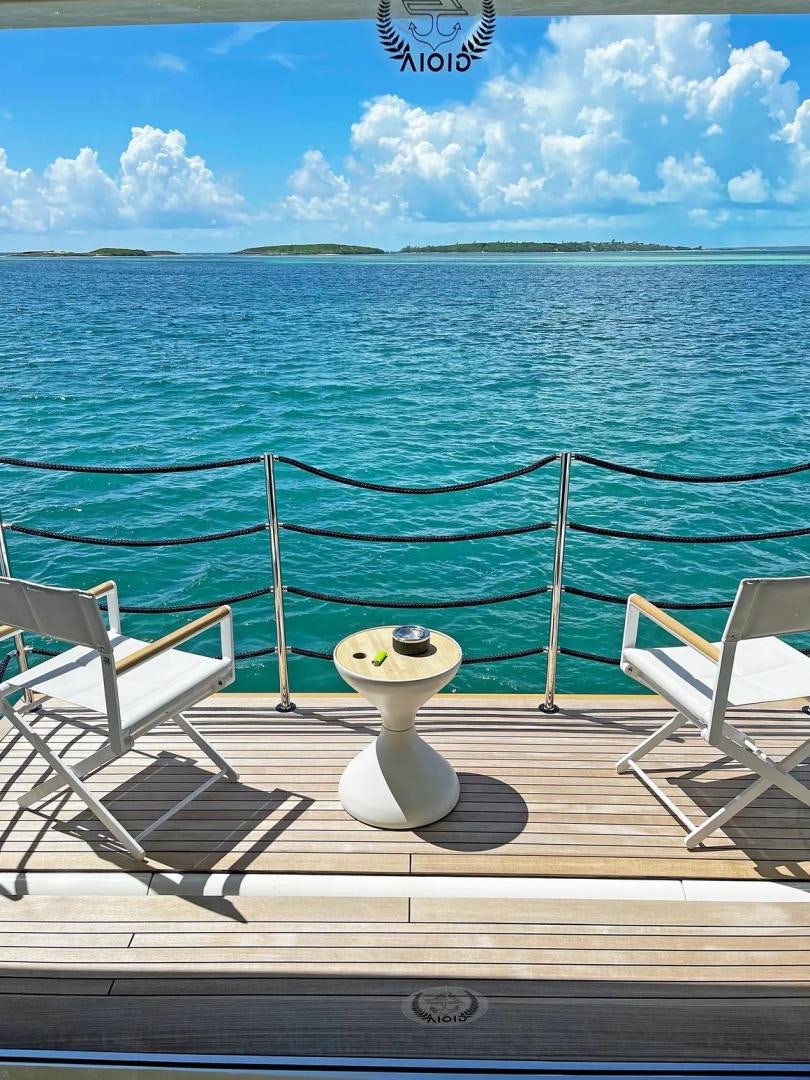 a deck with chairs and a body of water in the background aboard GIOIA Yacht for Sale