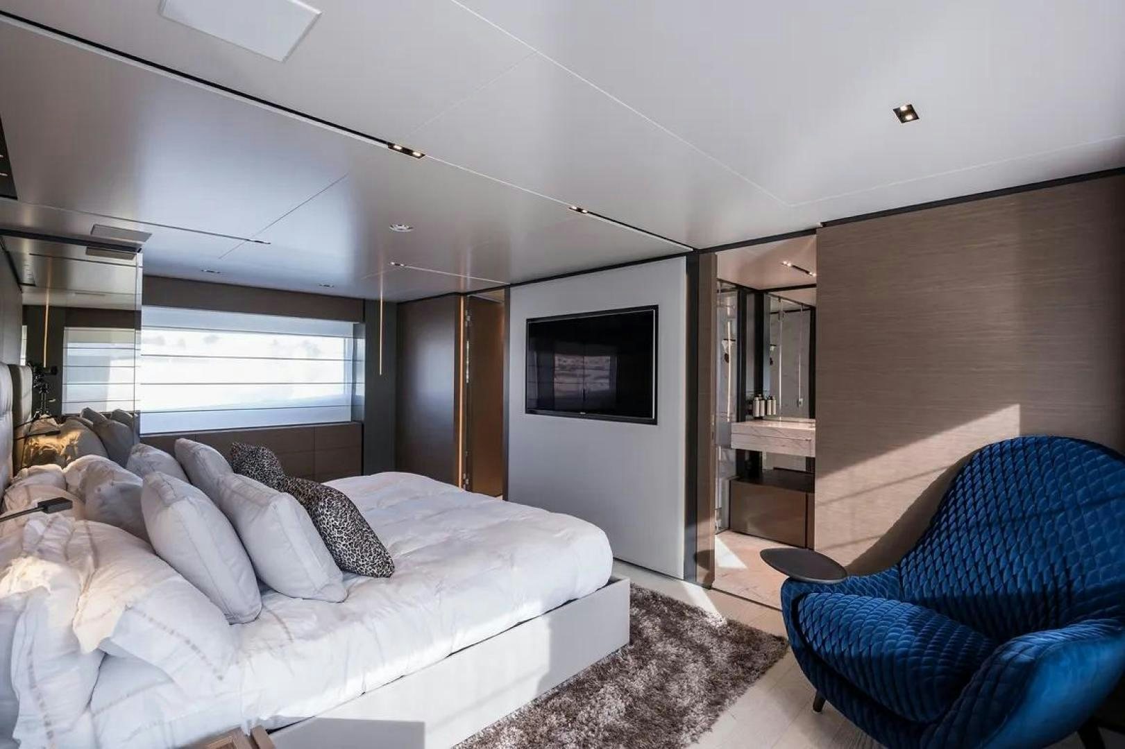 a bedroom with a bed and a blue couch aboard GIOIA Yacht for Sale
