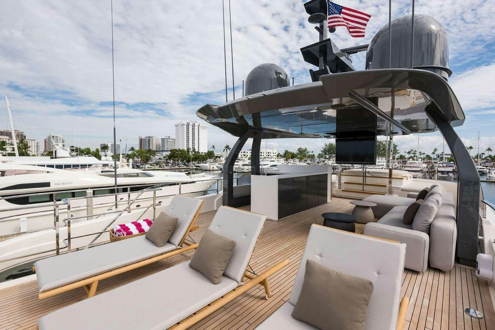 a deck with a view of a city and a large ship aboard GIOIA Yacht for Sale