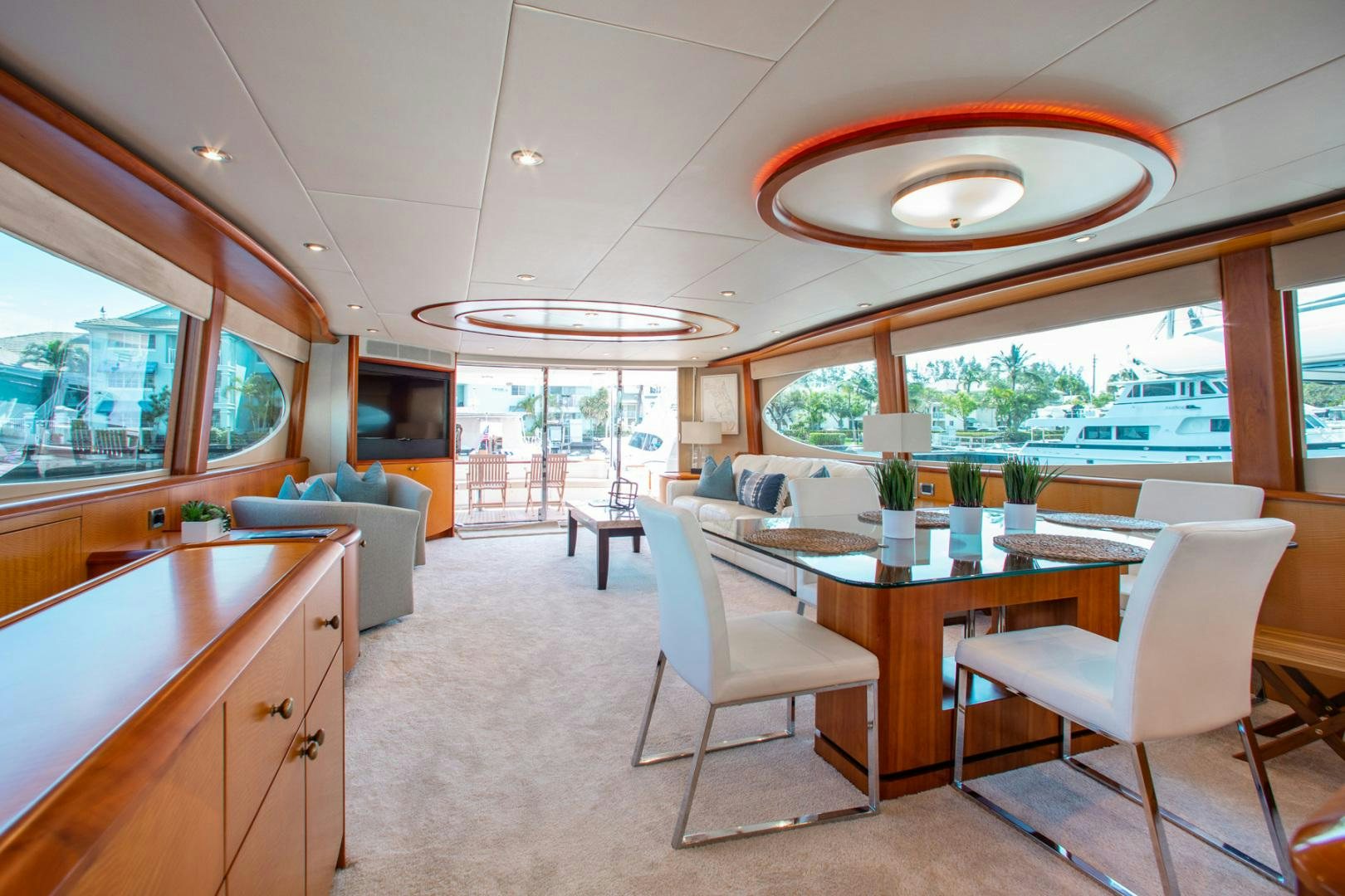 a large open living room with a dining table and chairs aboard 26 NORTH Yacht for Sale