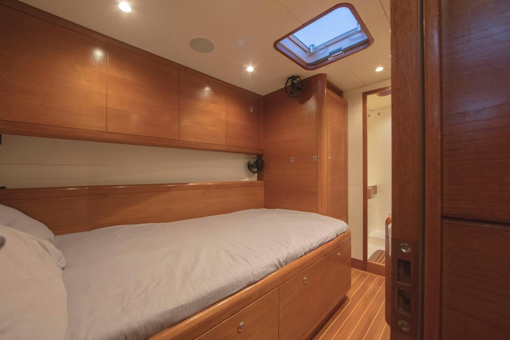 a bedroom with a bed and a wood cabinet aboard GREY GOOSE Yacht for Sale
