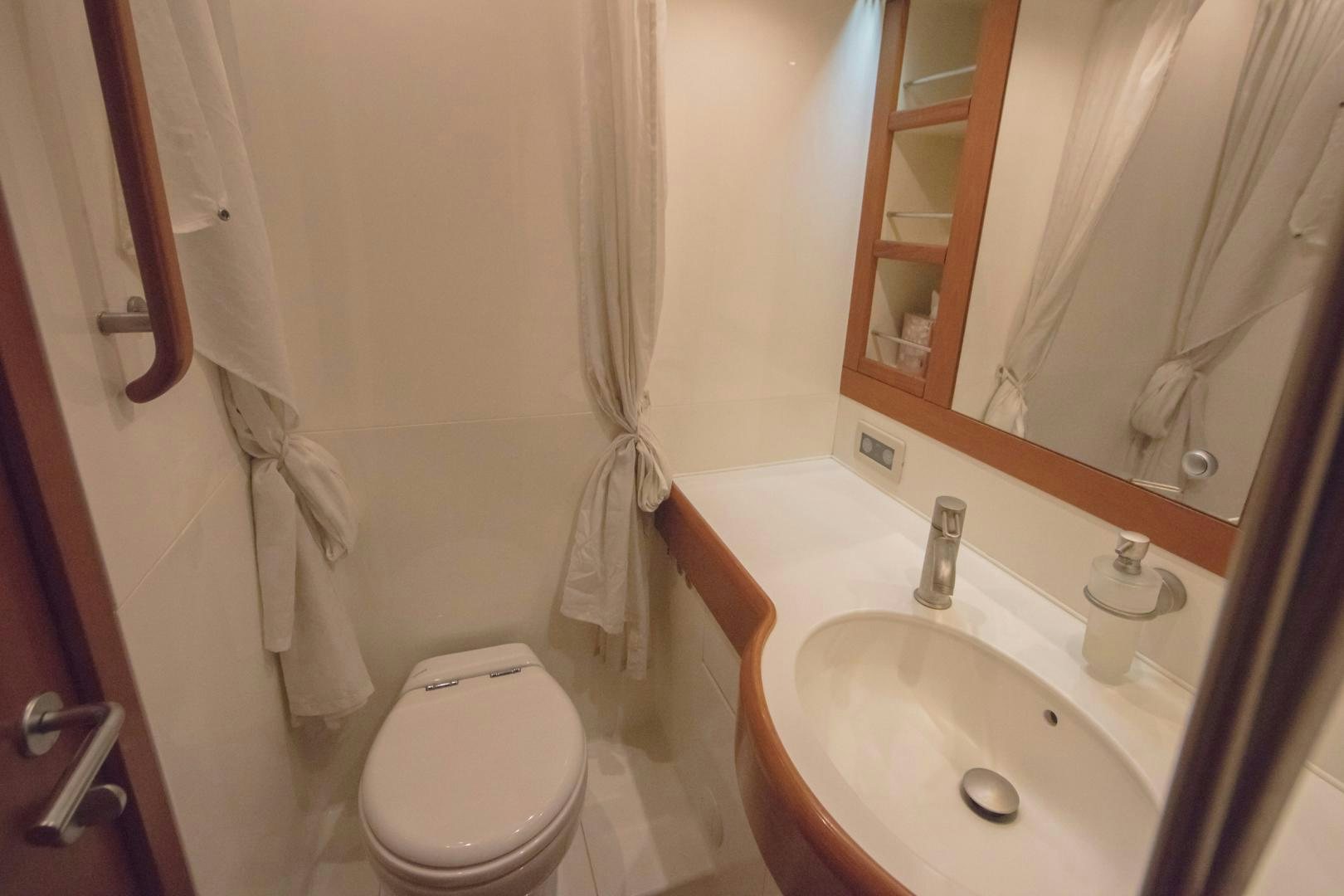 a bathroom with a sink toilet and a mirror aboard GREY GOOSE Yacht for Sale