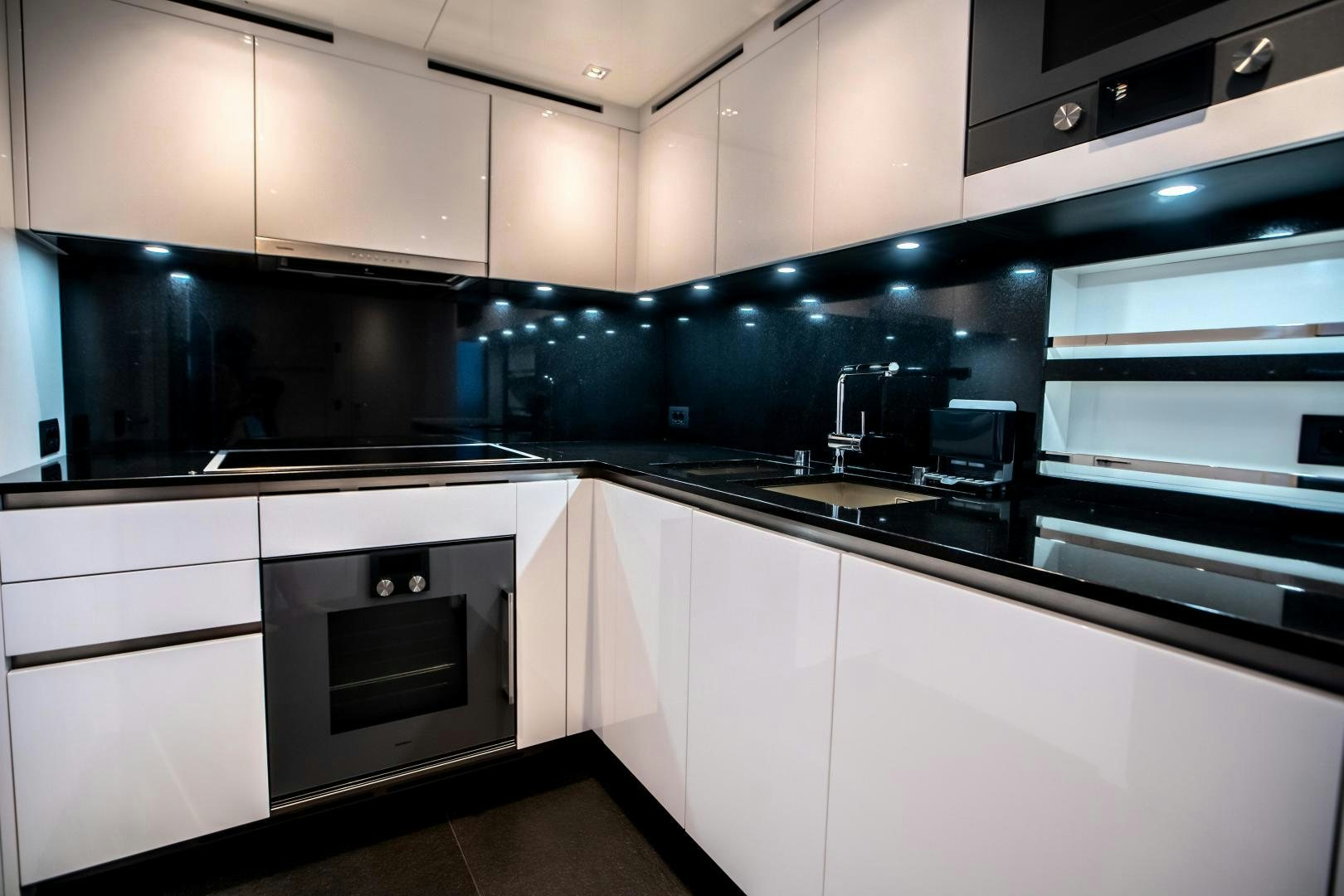 a kitchen with white cabinets aboard ACE Yacht for Sale