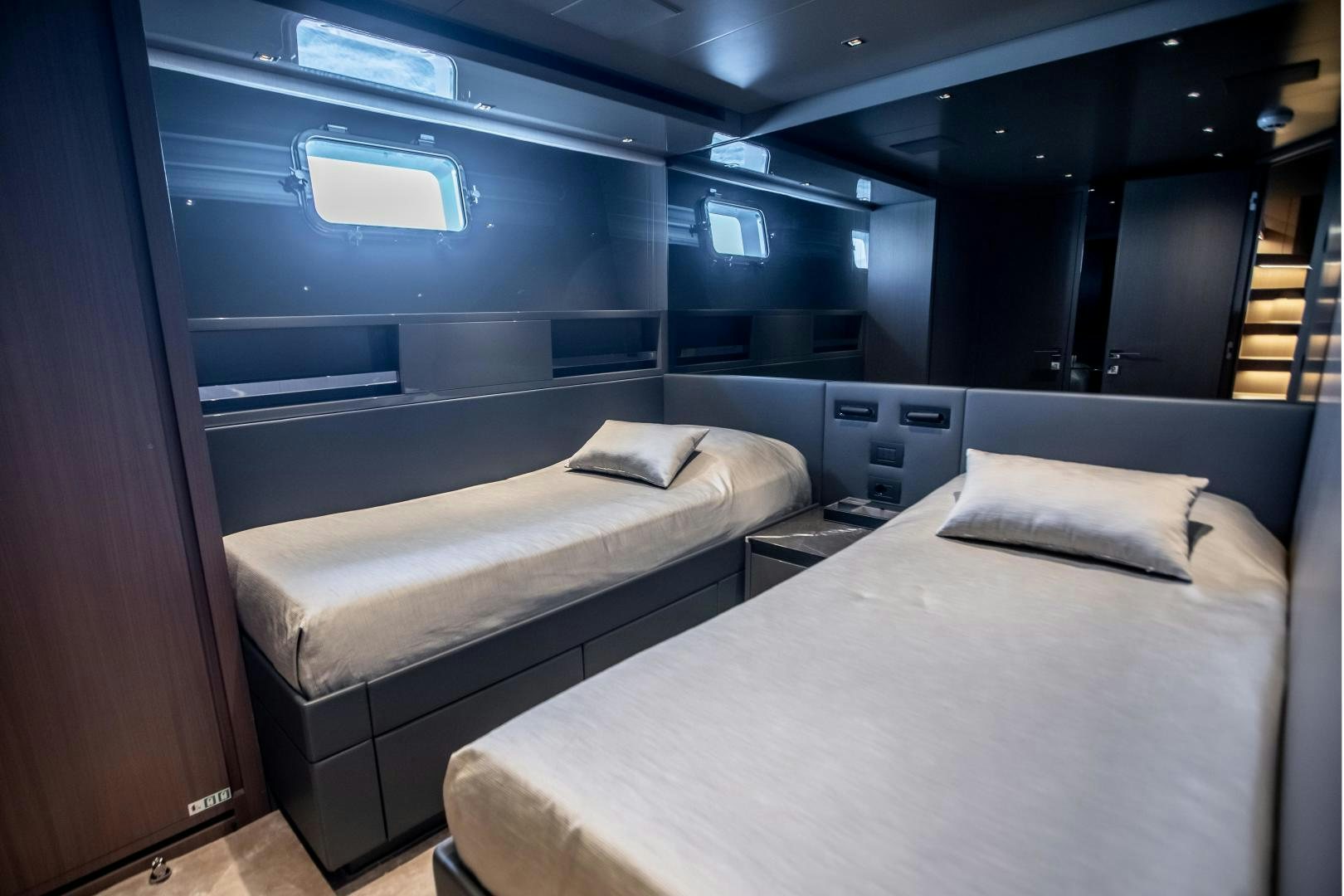 a room with beds and a window aboard ACE Yacht for Sale