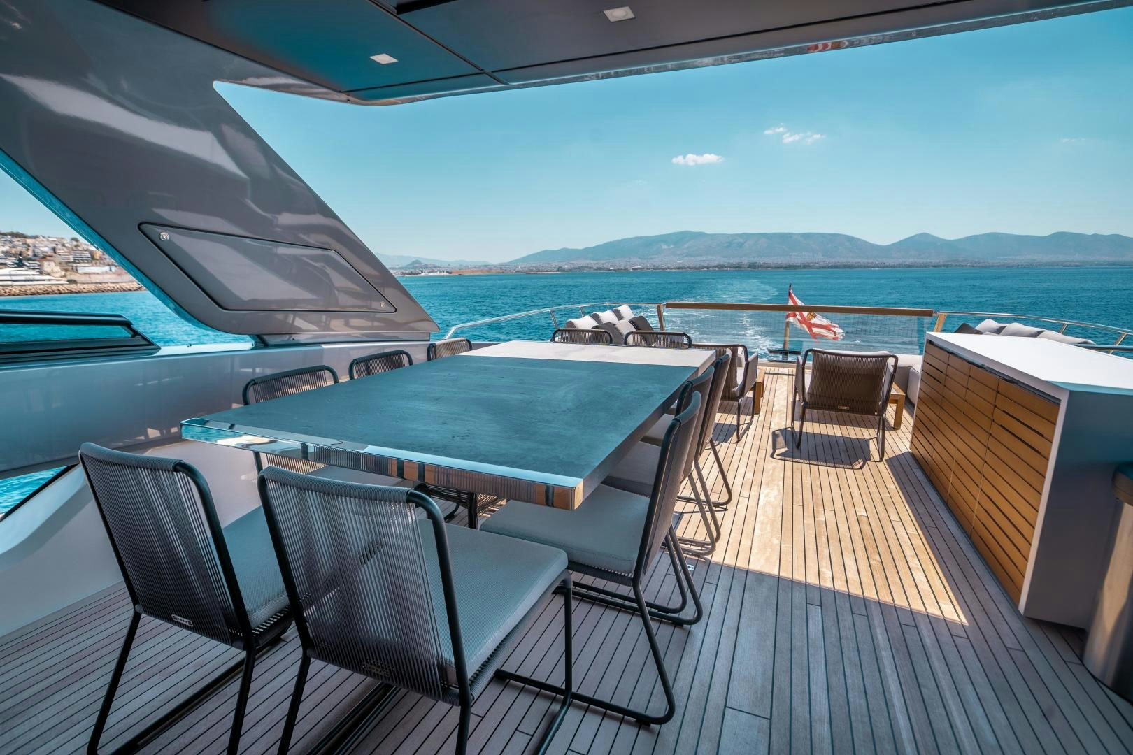 a deck with a view of the ocean and mountains aboard ACE Yacht for Sale