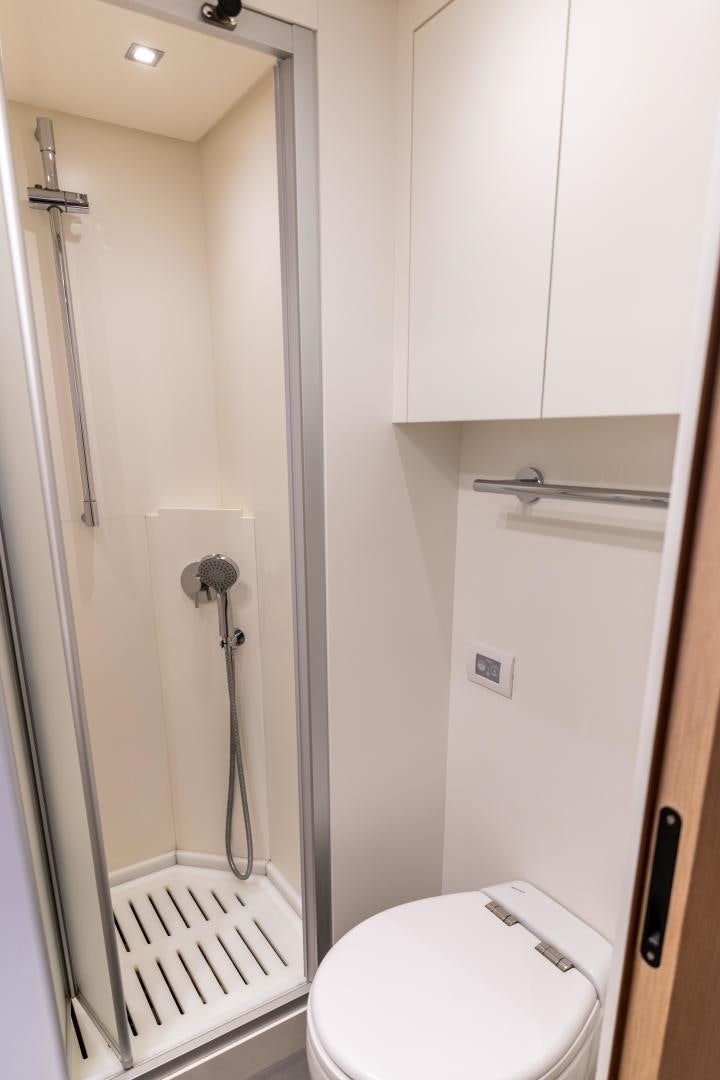 a bathroom with a toilet and a shower unit aboard ACE Yacht for Sale