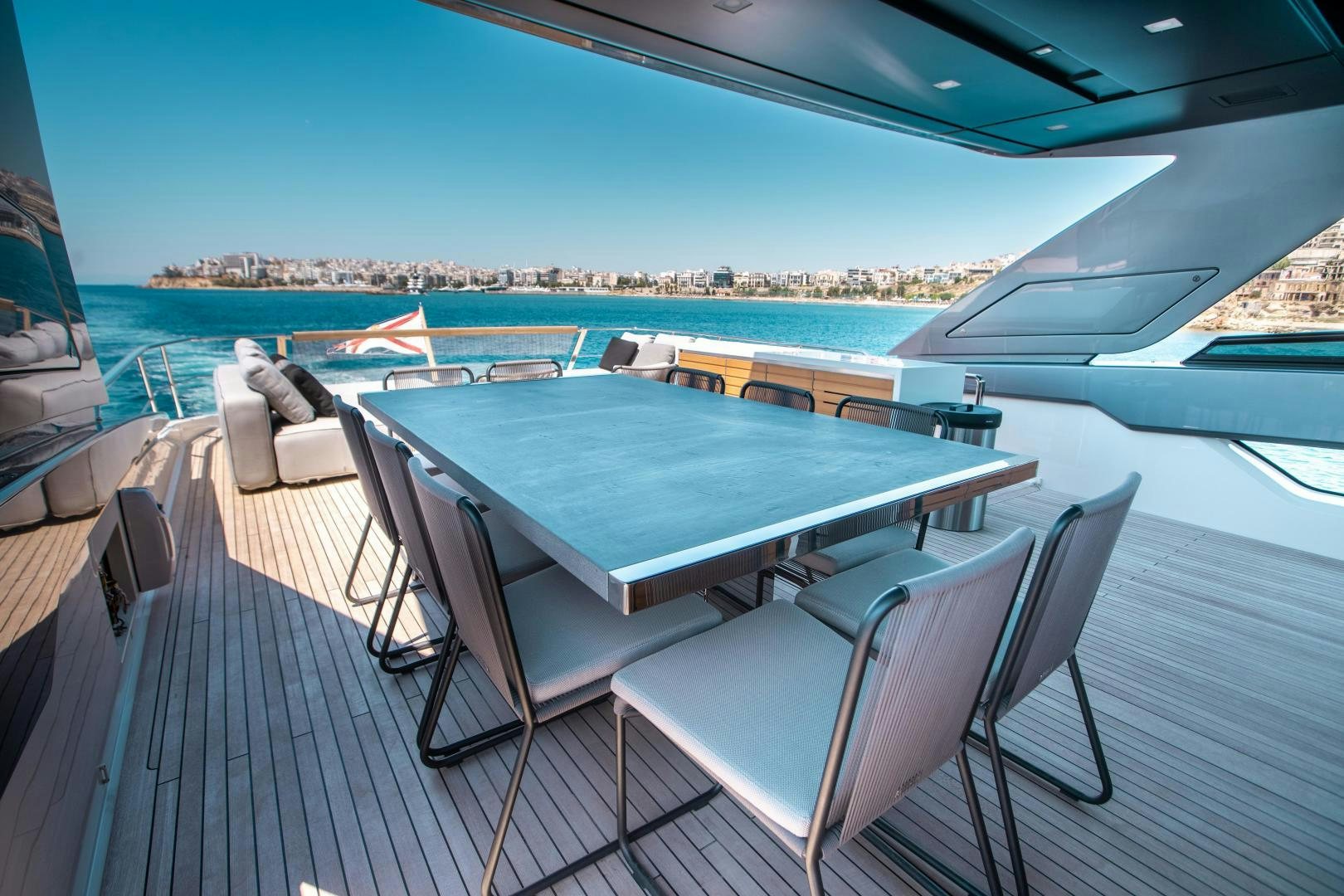a table and chairs on a deck overlooking a body of water aboard ACE Yacht for Sale