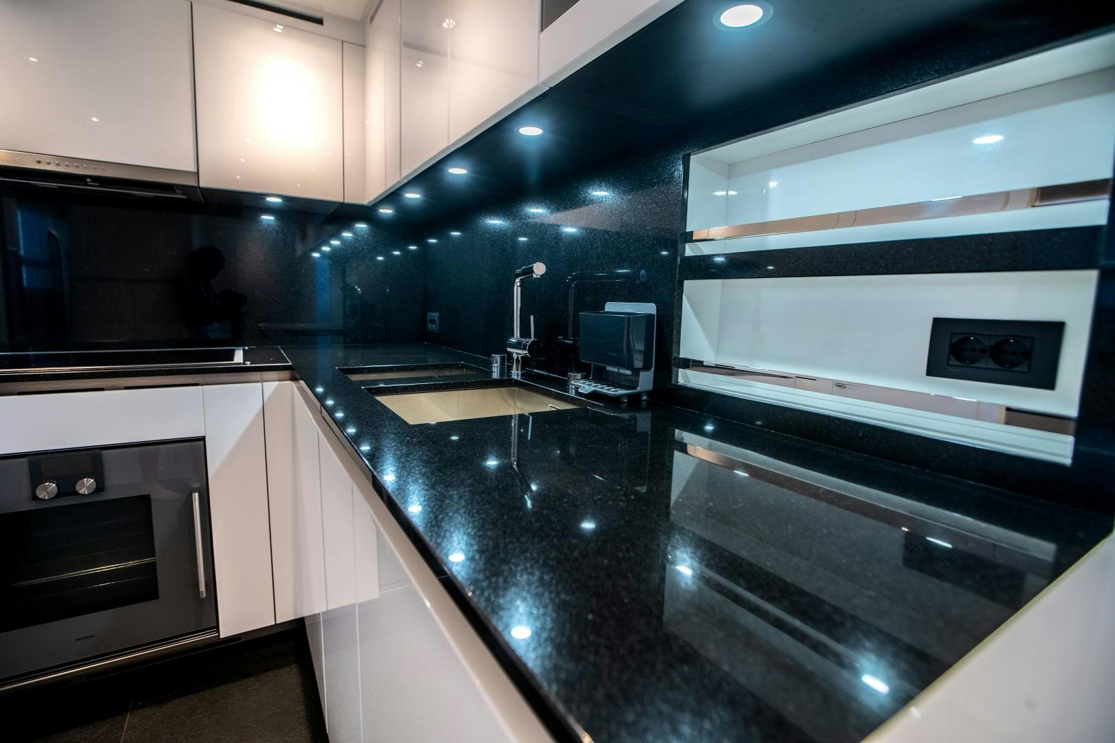 a kitchen with black counter tops aboard ACE Yacht for Sale