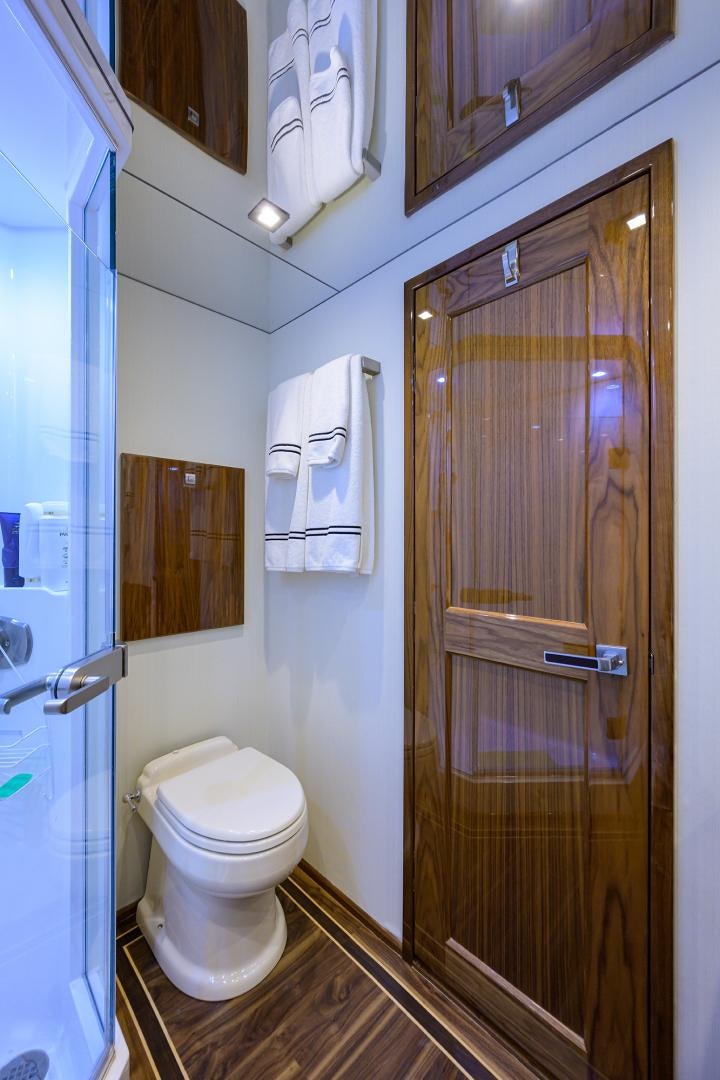 a bathroom with a toilet and a door aboard SET IN MY WAVES Yacht for Sale