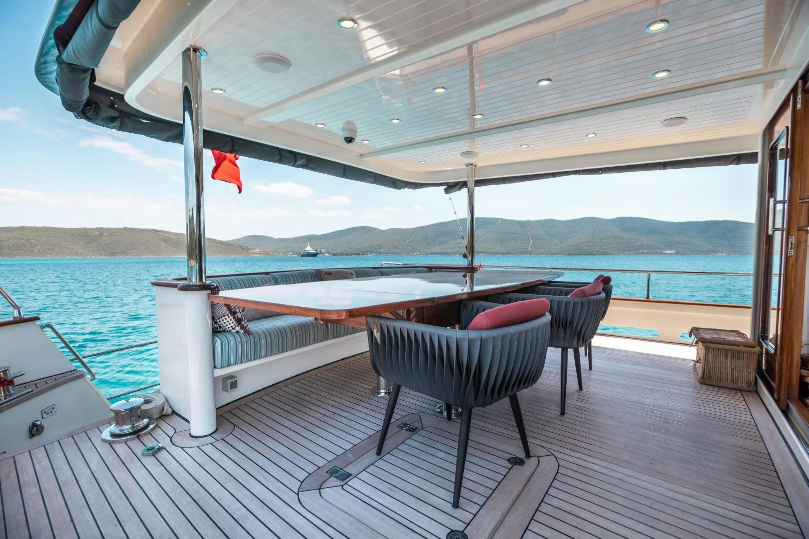 a deck with a chair and a table on it aboard DILNISIN Yacht for Sale