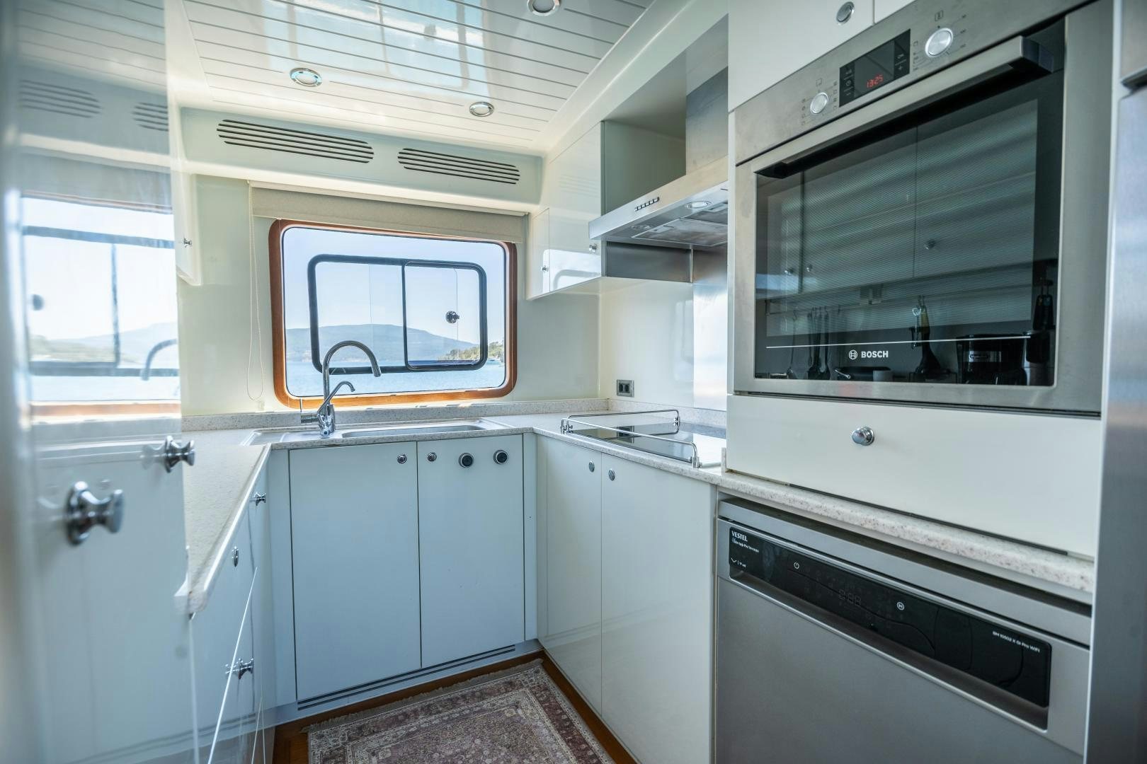 a kitchen with white cabinets aboard DILNISIN Yacht for Sale