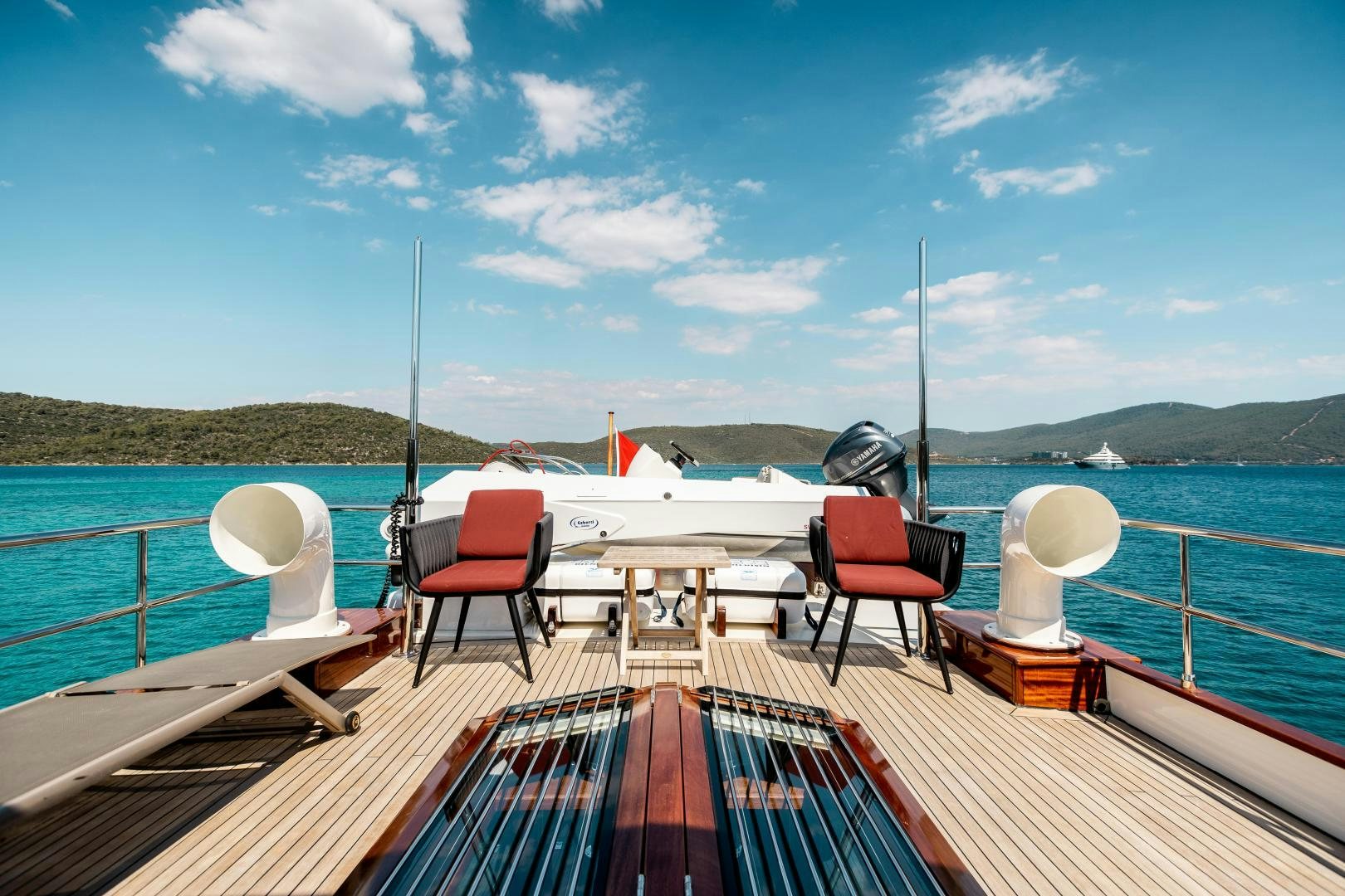 a deck with chairs and tables on it by the water aboard DILNISIN Yacht for Sale