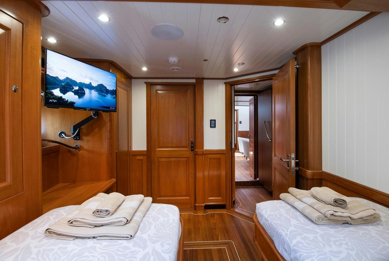 a room with a bed and a television on the wall aboard MELODY Yacht for Sale