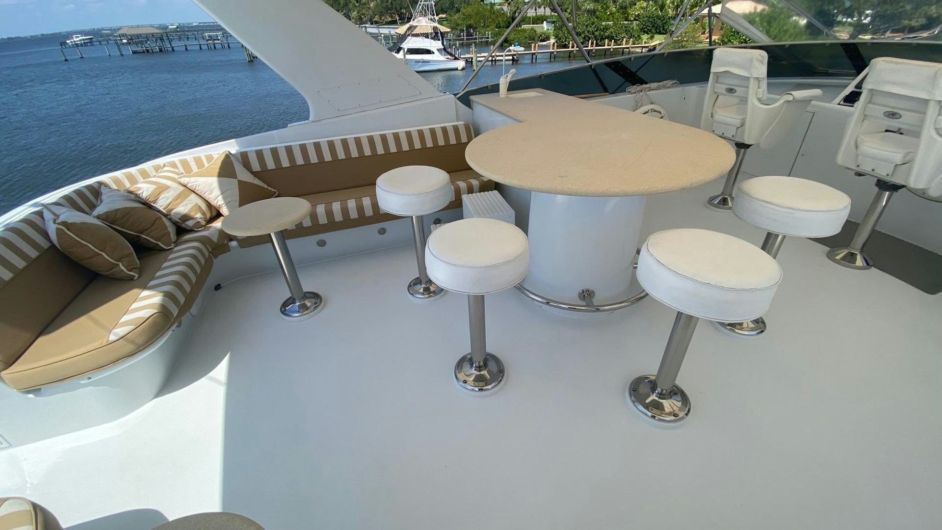 a group of stools on a deck overlooking a body of water aboard SOCIAL DIRECTOR Yacht for Sale
