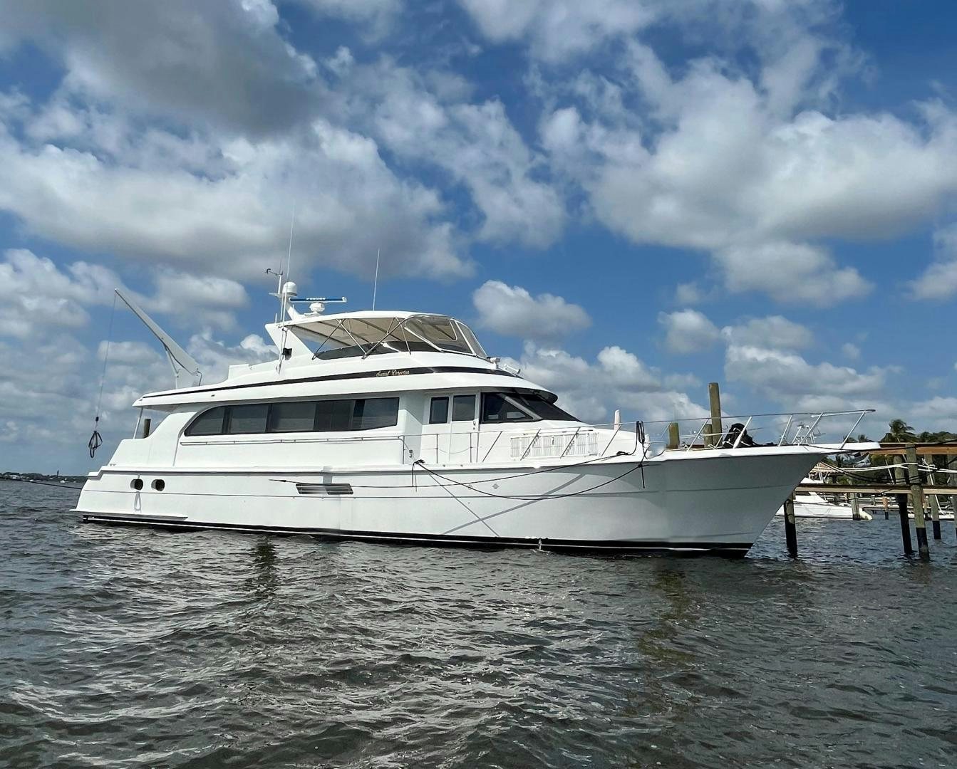 a white yacht docked at a dock aboard SOCIAL DIRECTOR Yacht for Sale