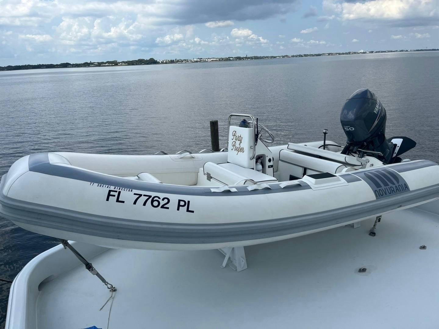 a white boat with a black and white engine on the front aboard SOCIAL DIRECTOR Yacht for Sale