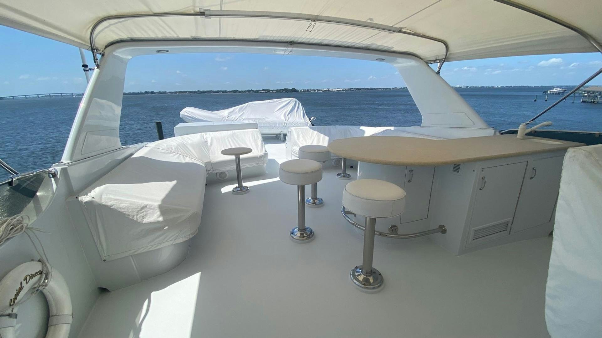 a boat with a table and stools on it aboard SOCIAL DIRECTOR Yacht for Sale