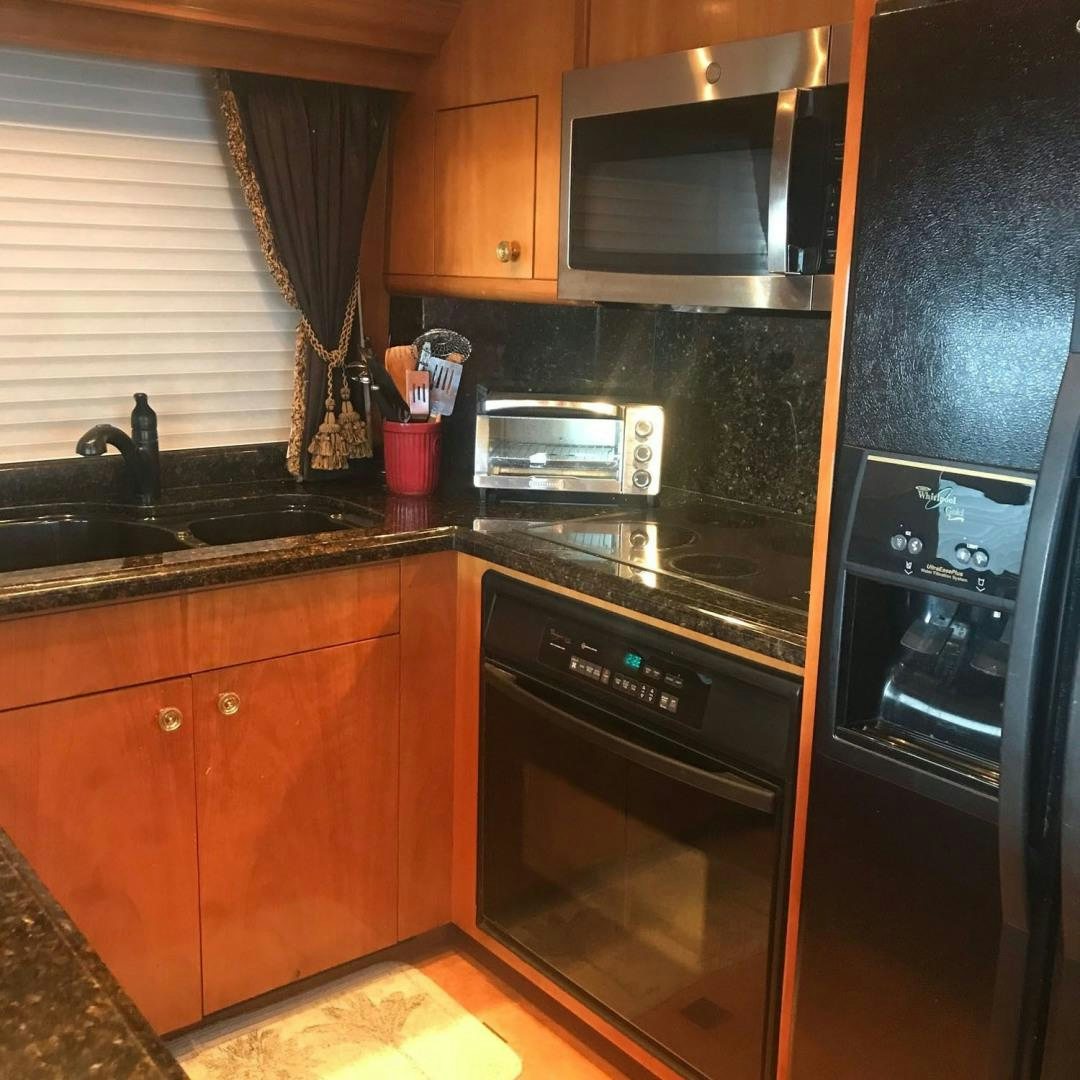 a kitchen with black appliances aboard SOCIAL DIRECTOR Yacht for Sale