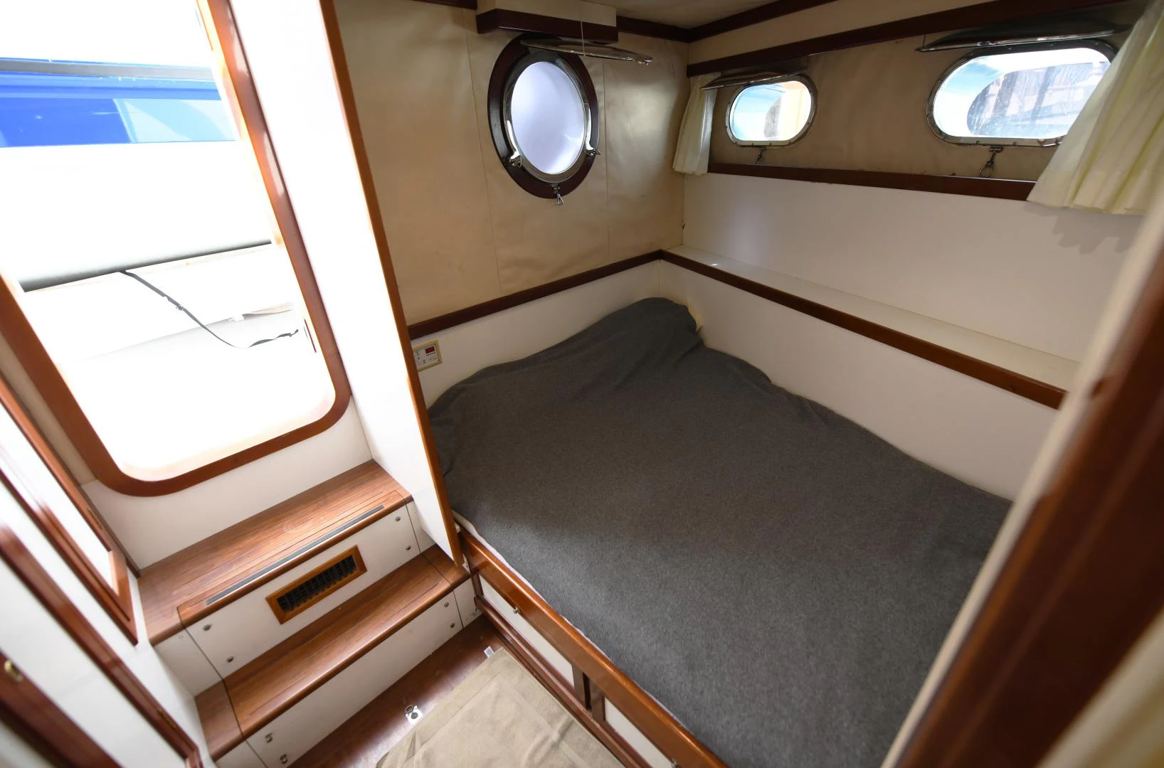 a small room with a bed and a window aboard AMARELLA F Yacht for Sale