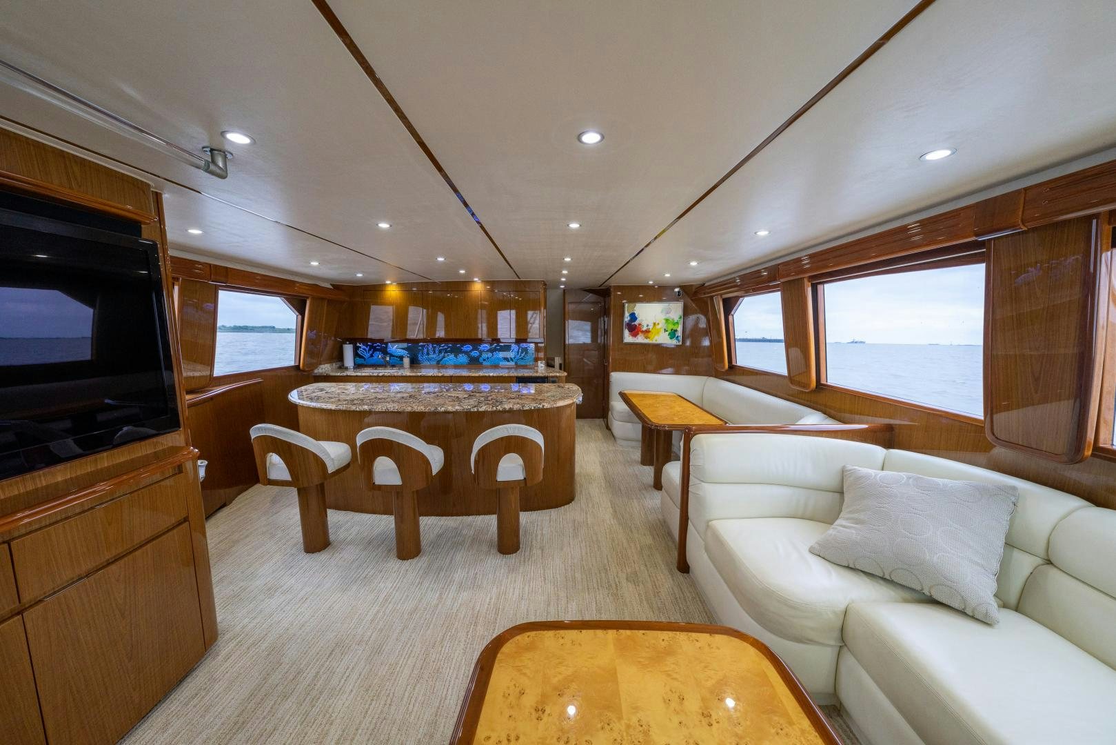 a living room with a large television and a table aboard MM CRICKET Yacht for Sale