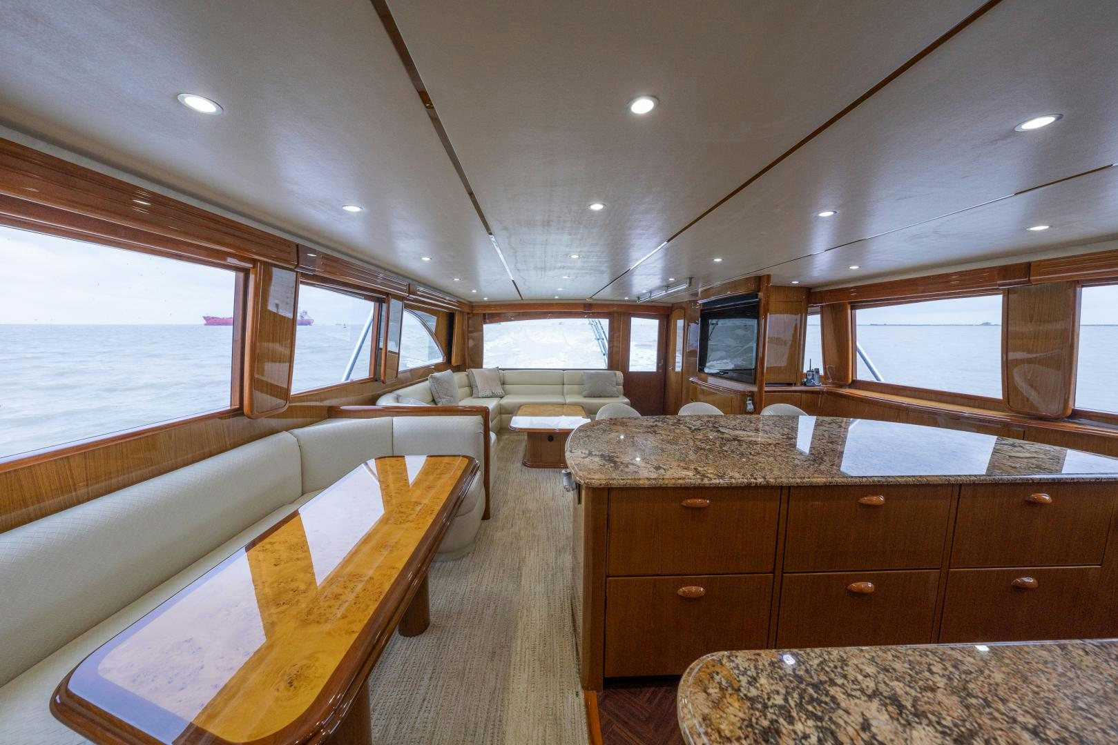 a large living room with a large window and wood cabinets aboard MM CRICKET Yacht for Sale