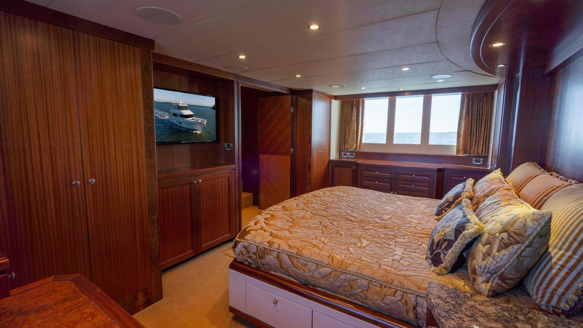 a bedroom with a bed and a wood cabinet aboard RHYTHM'N BLUES Yacht for Sale