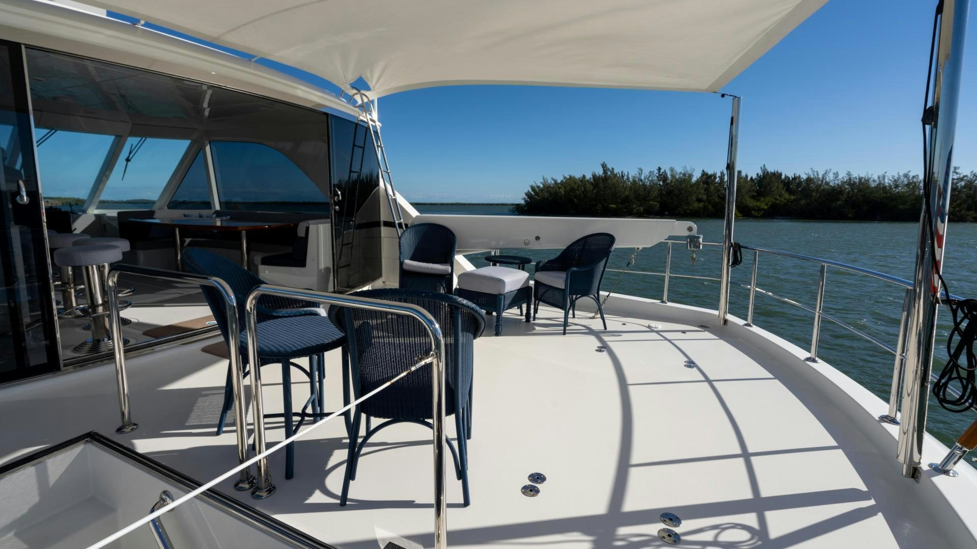 a large white deck with chairs and tables on it aboard RHYTHM'N BLUES Yacht for Sale