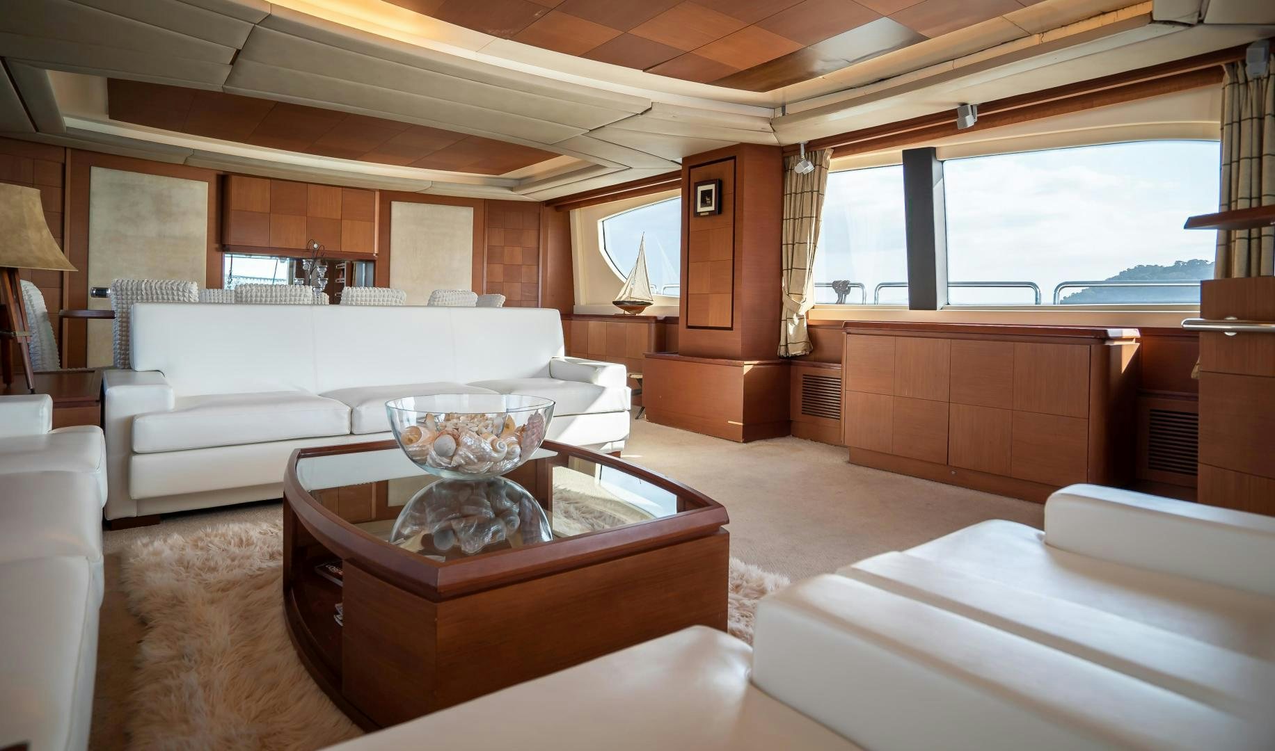 a large living room with a large white couch and a large window aboard CAMY ED Yacht for Sale