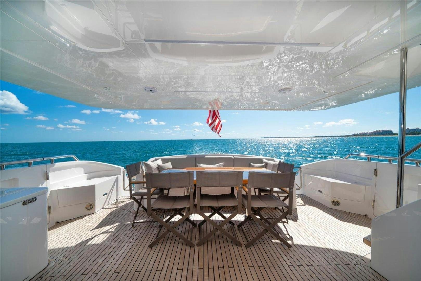 a deck with chairs and a table on it aboard VALIANT Yacht for Sale