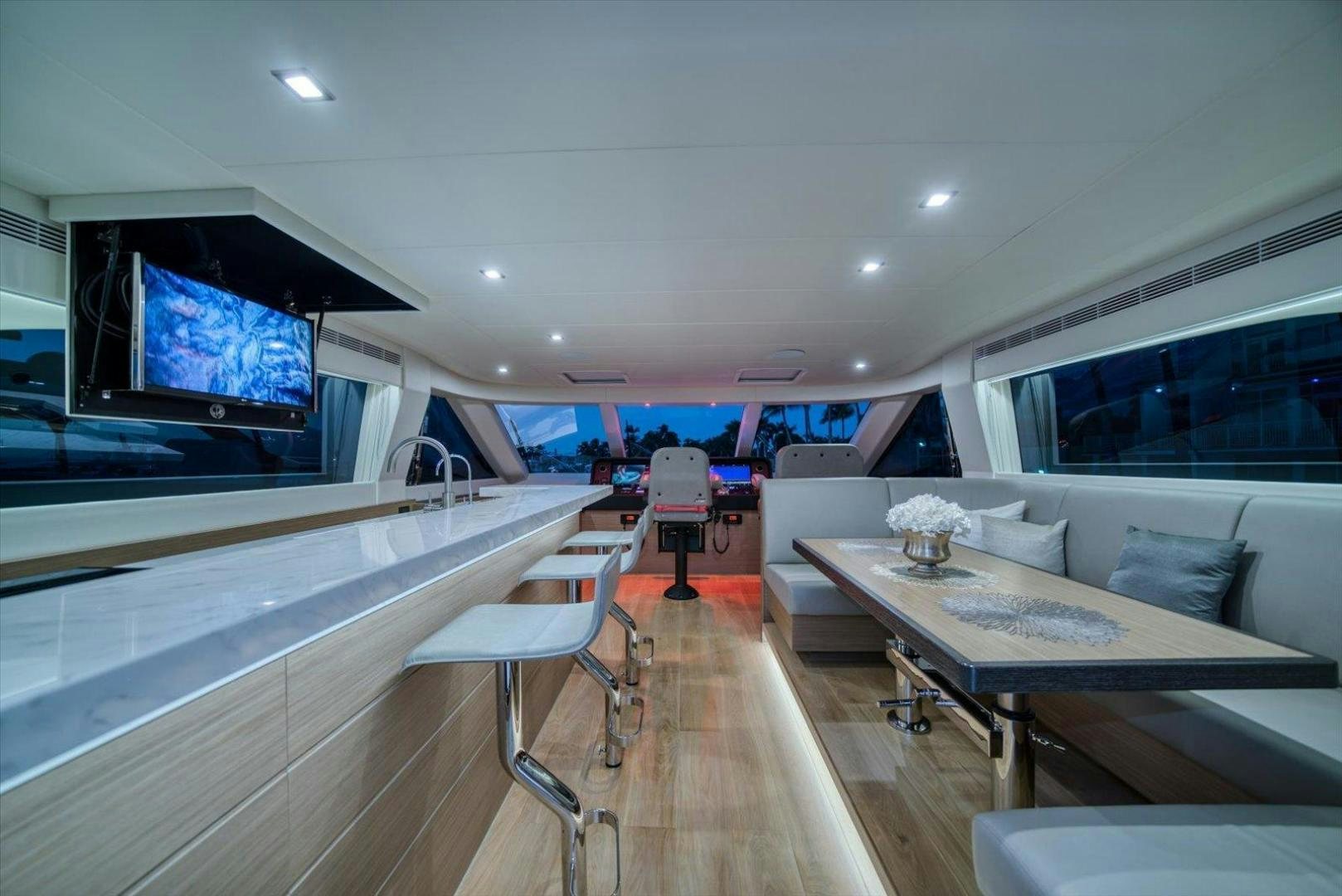 a room with a large window and a table with chairs and a tv aboard VALIANT Yacht for Sale