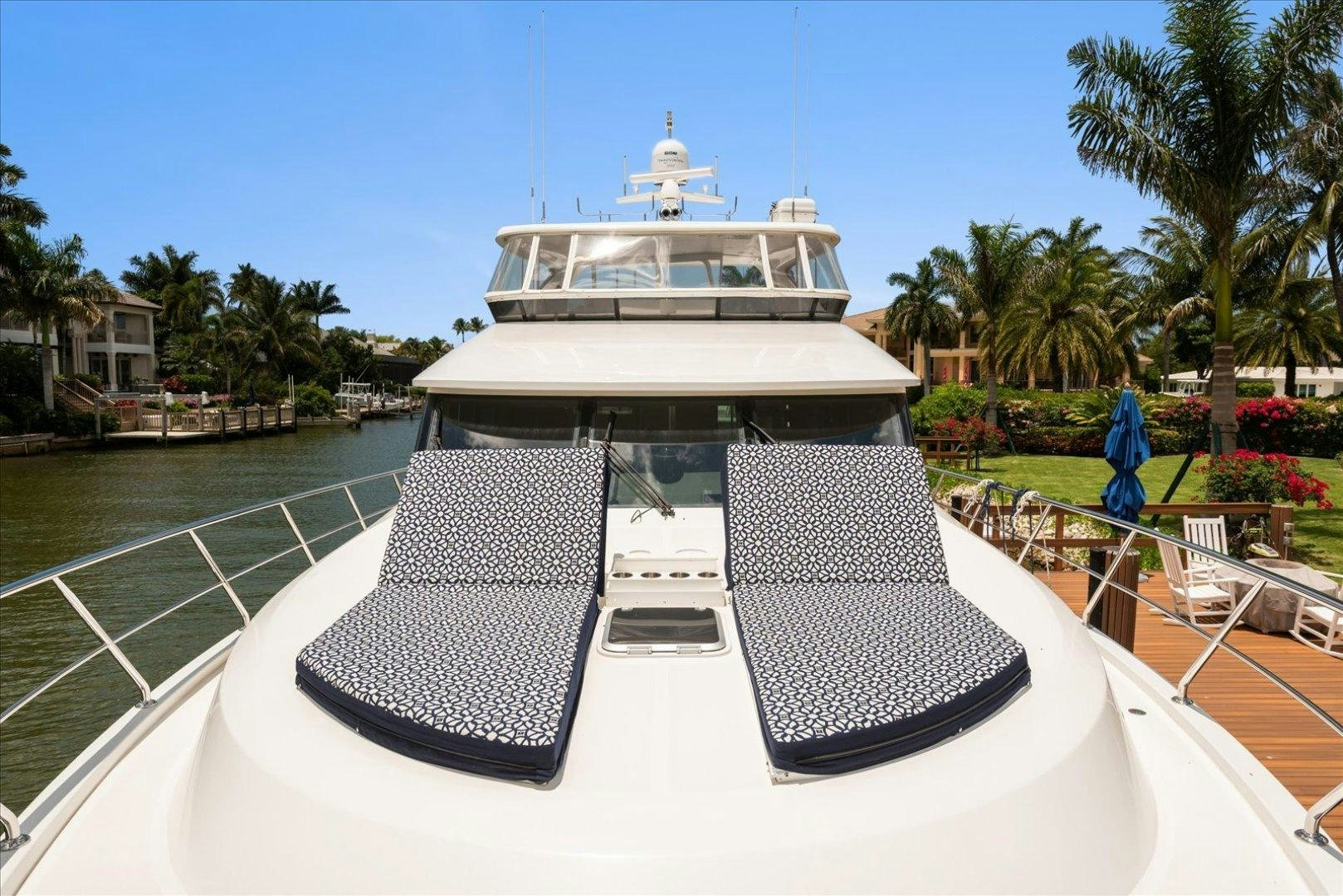 a white building with a dome and a pool with chairs and trees aboard Goodlife Yacht for Sale