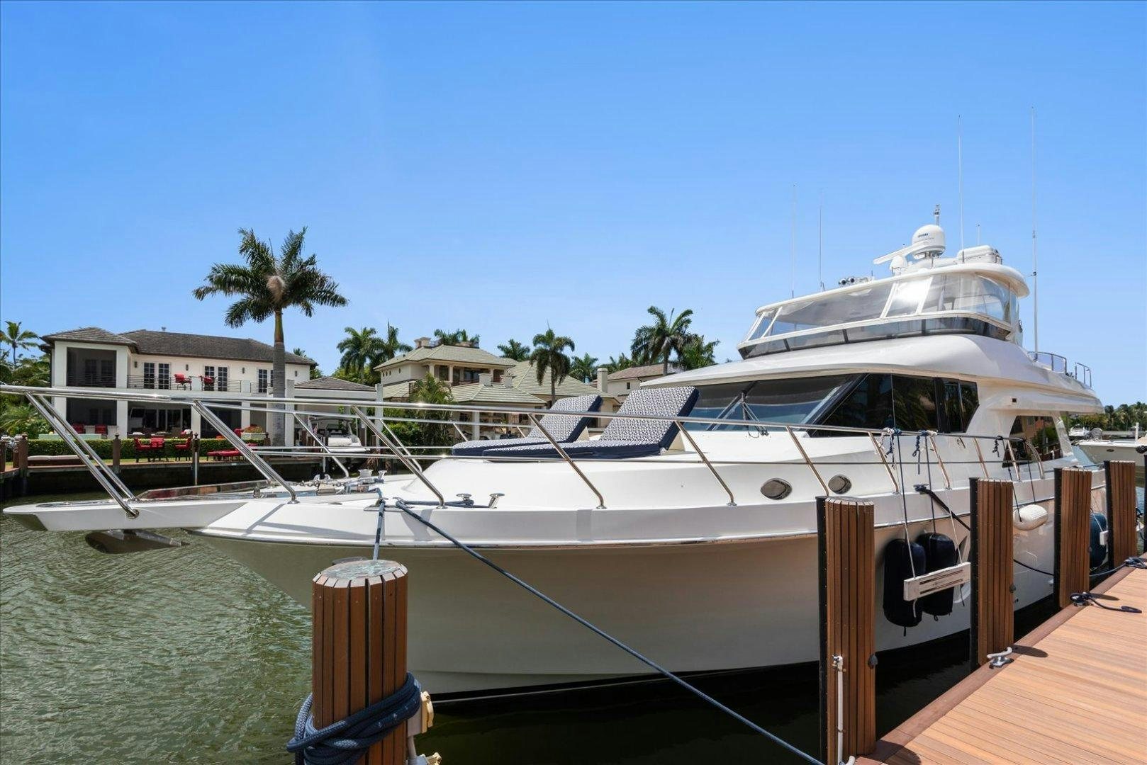 a white yacht docked at a pier aboard Goodlife Yacht for Sale