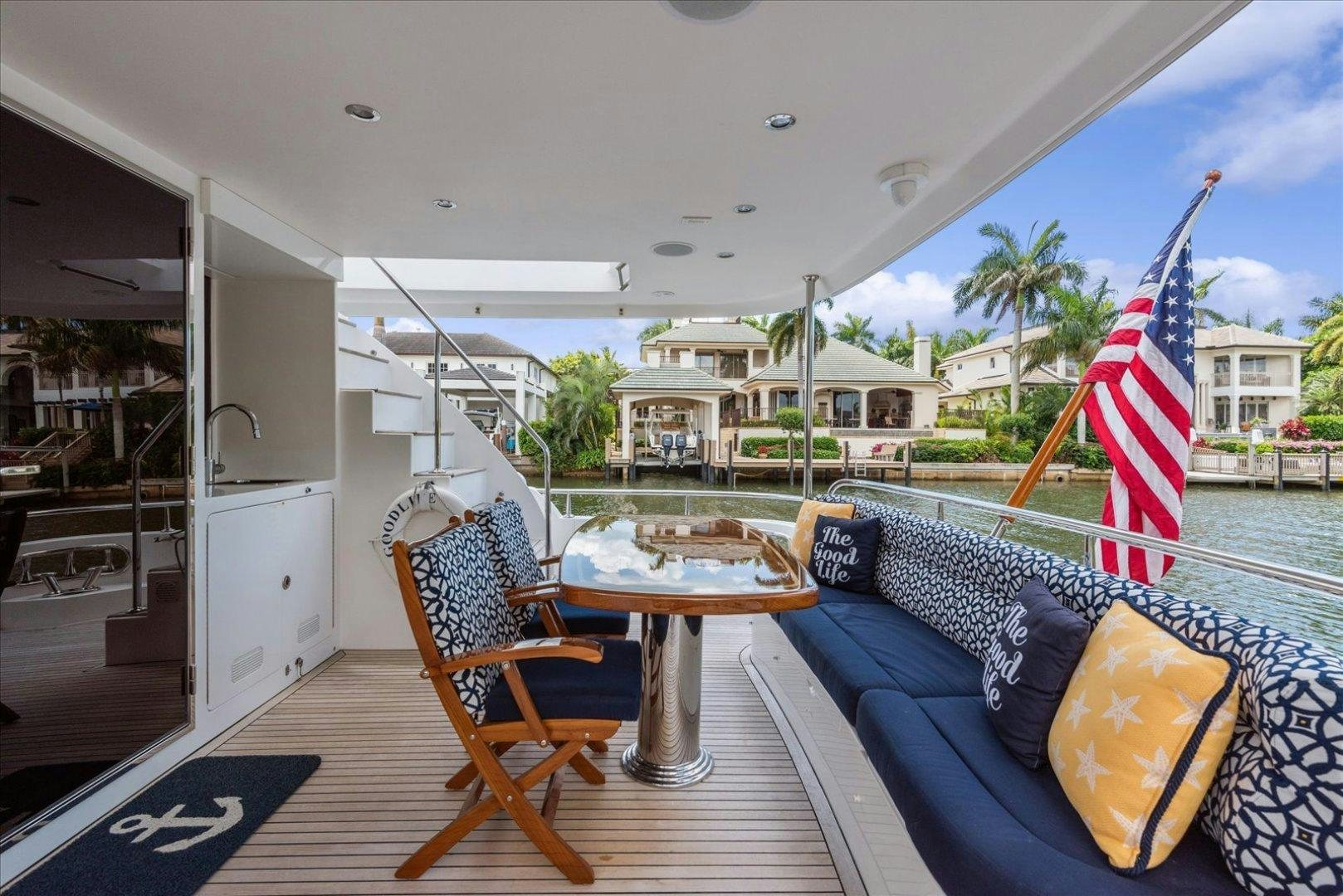 a deck with a table and chairs on it aboard Goodlife Yacht for Sale