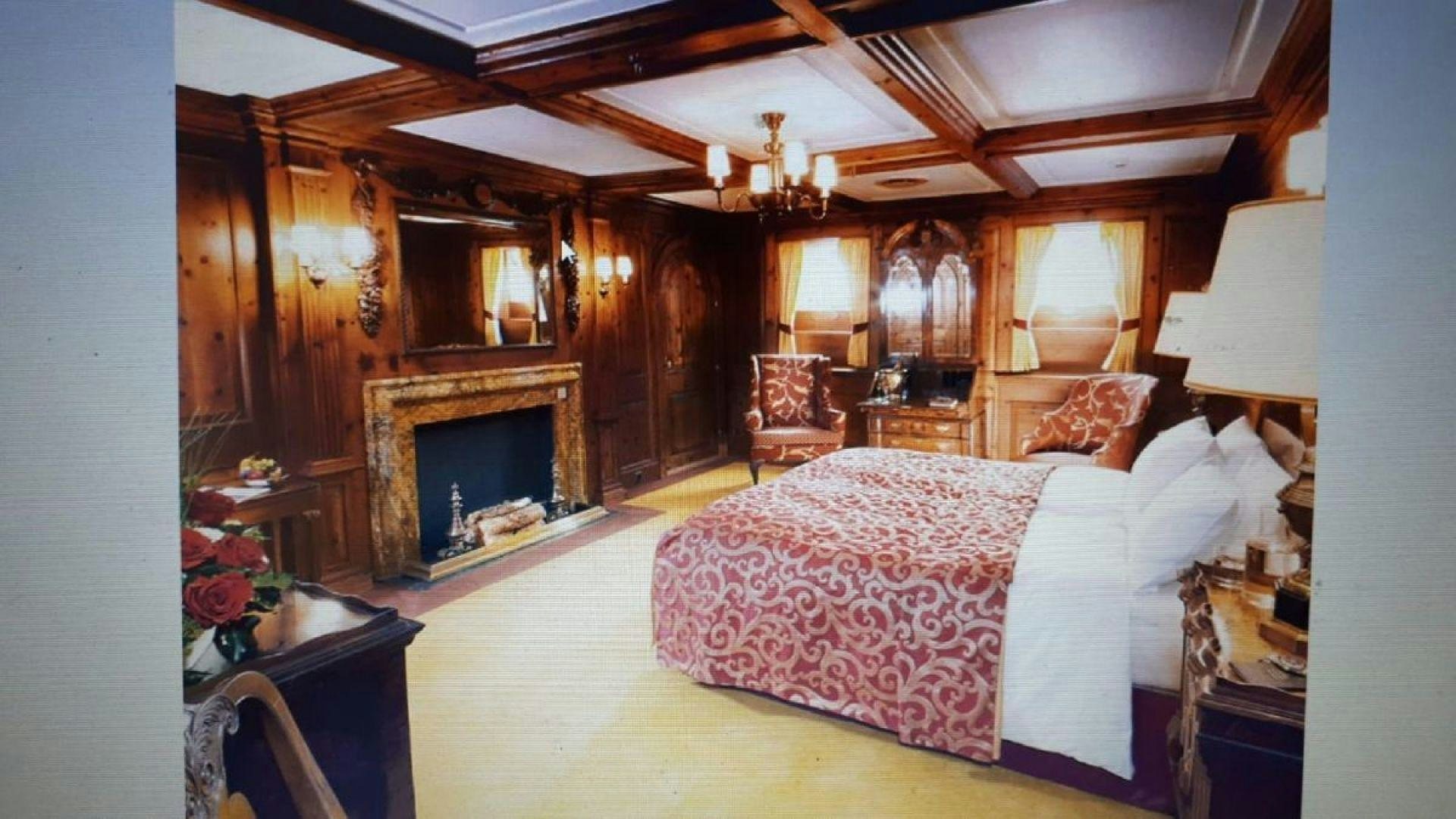 a bedroom with a fireplace aboard USS WILLIAMSBURG Yacht for Sale