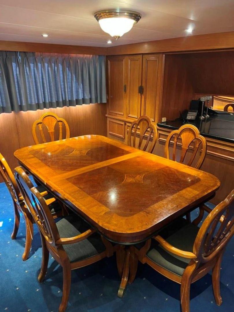 a table with chairs around it aboard AQUILA JOVIS Yacht for Sale