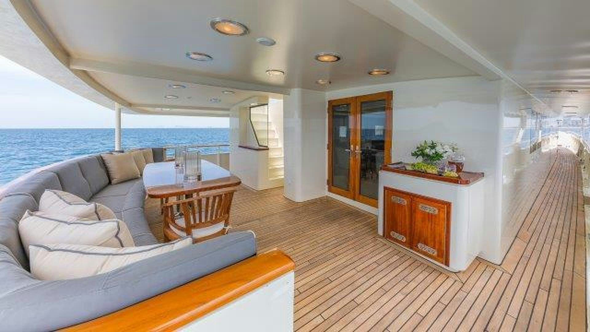 a room with a table and a couch and a large window aboard ARIADNE Yacht for Sale