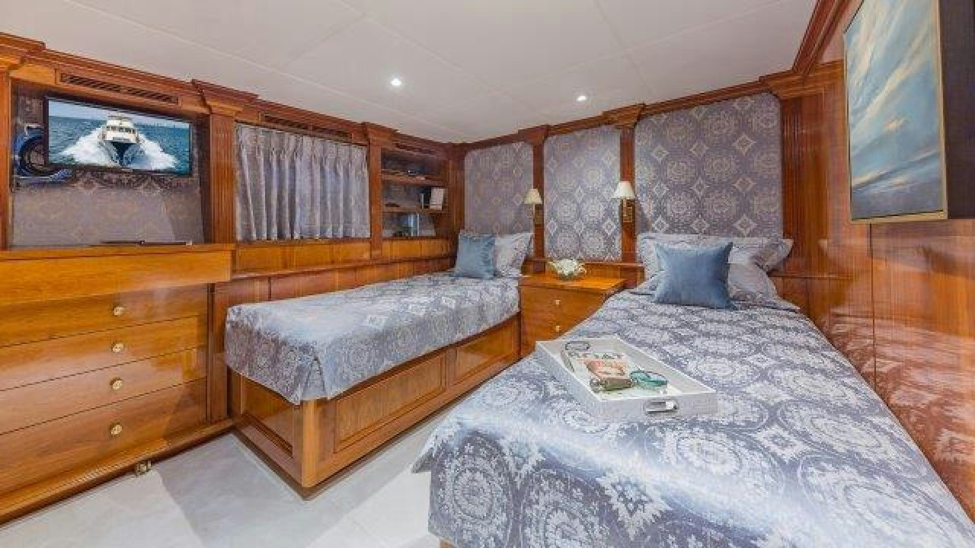 a bedroom with a bed and a dresser aboard ARIADNE Yacht for Sale