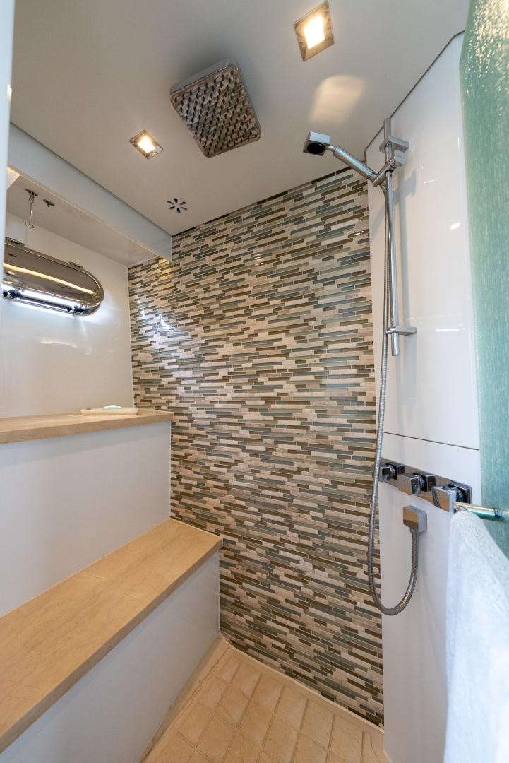 a shower with a tile wall aboard ENCORE Yacht for Sale