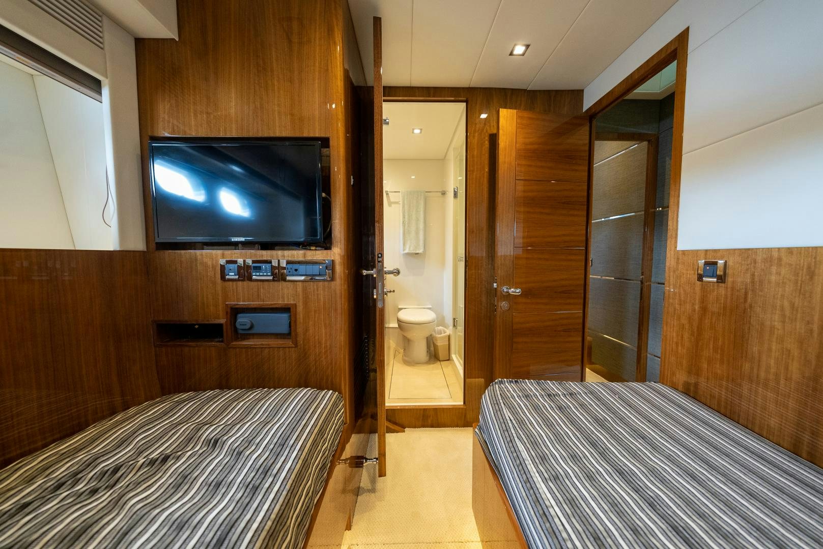 a bed and a television in a room aboard ENCORE Yacht for Sale