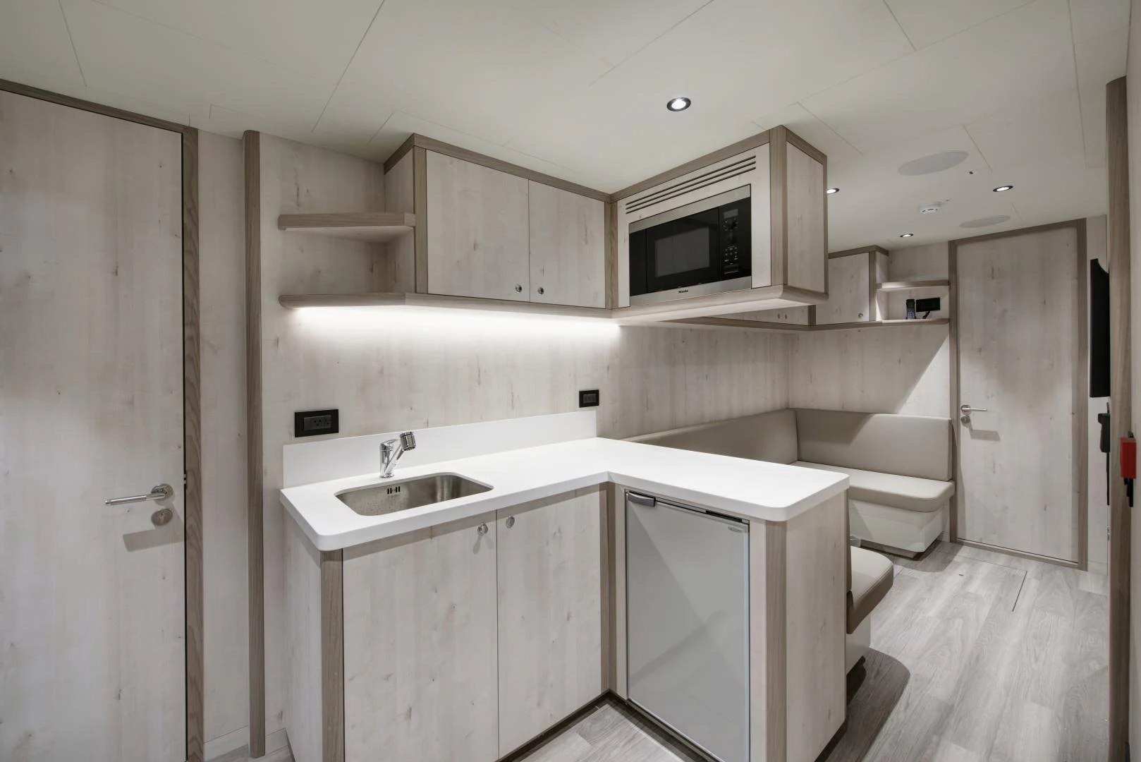 a kitchen with white cabinets aboard ALFRESCO 125 Yacht for Sale