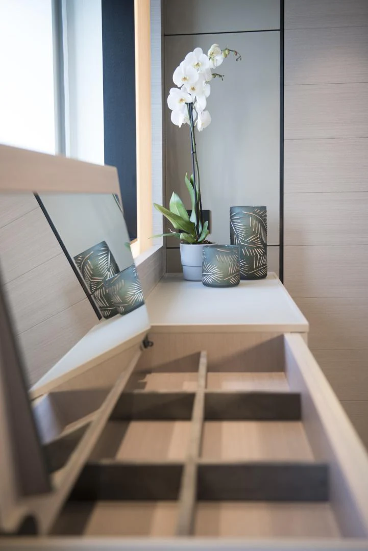 a desk with a laptop and flowers aboard ALFRESCO 125 Yacht for Sale