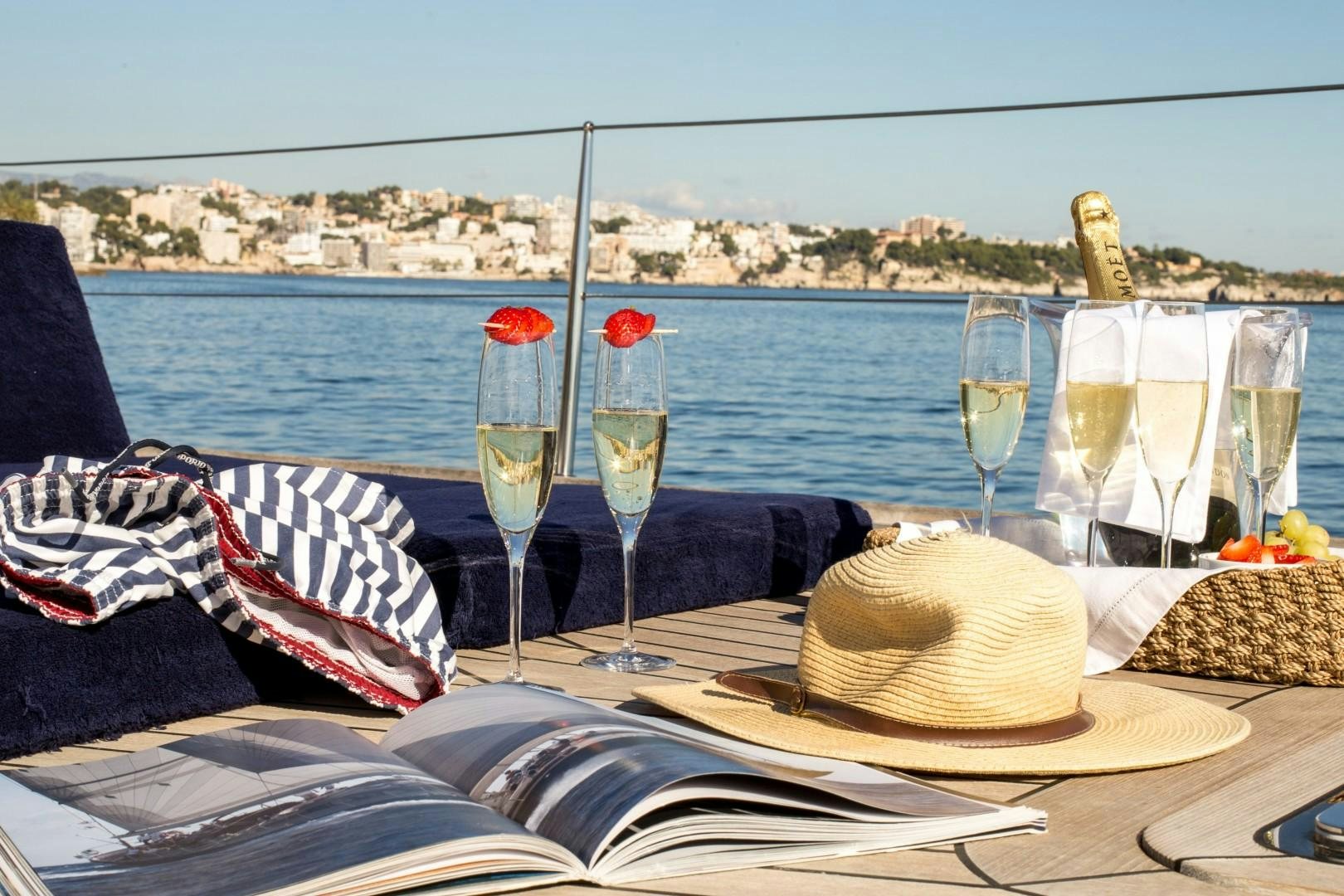 a table with wine glasses and a hat on it aboard UMIKO Yacht for Sale
