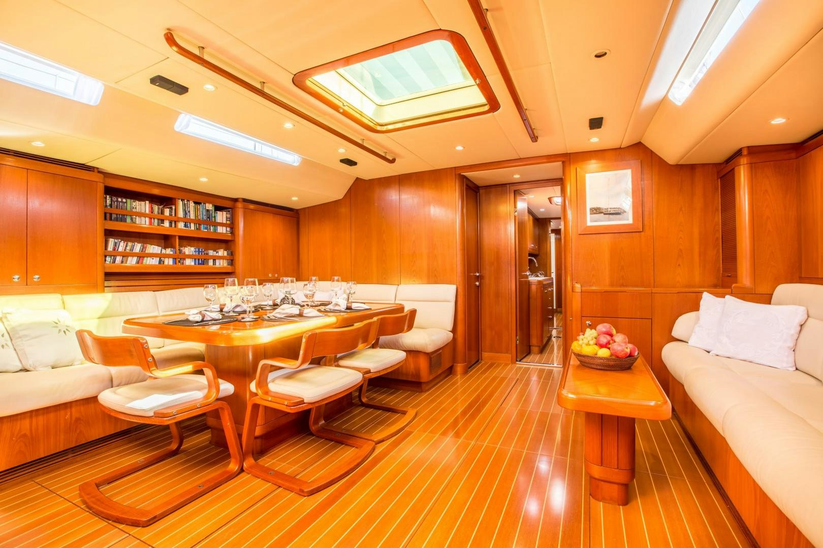 a room with a table chairs and a couch aboard UMIKO Yacht for Sale