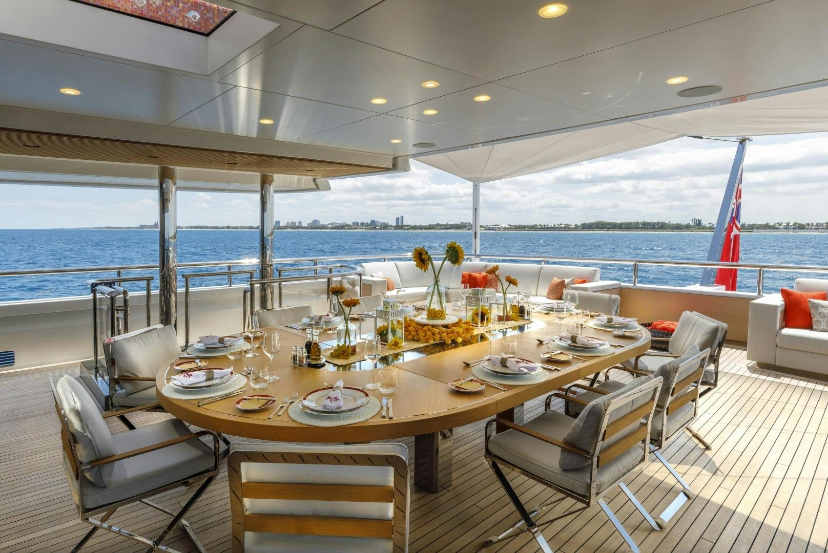 a table set for a meal on a deck overlooking the ocean aboard ATOMIC Yacht for Sale
