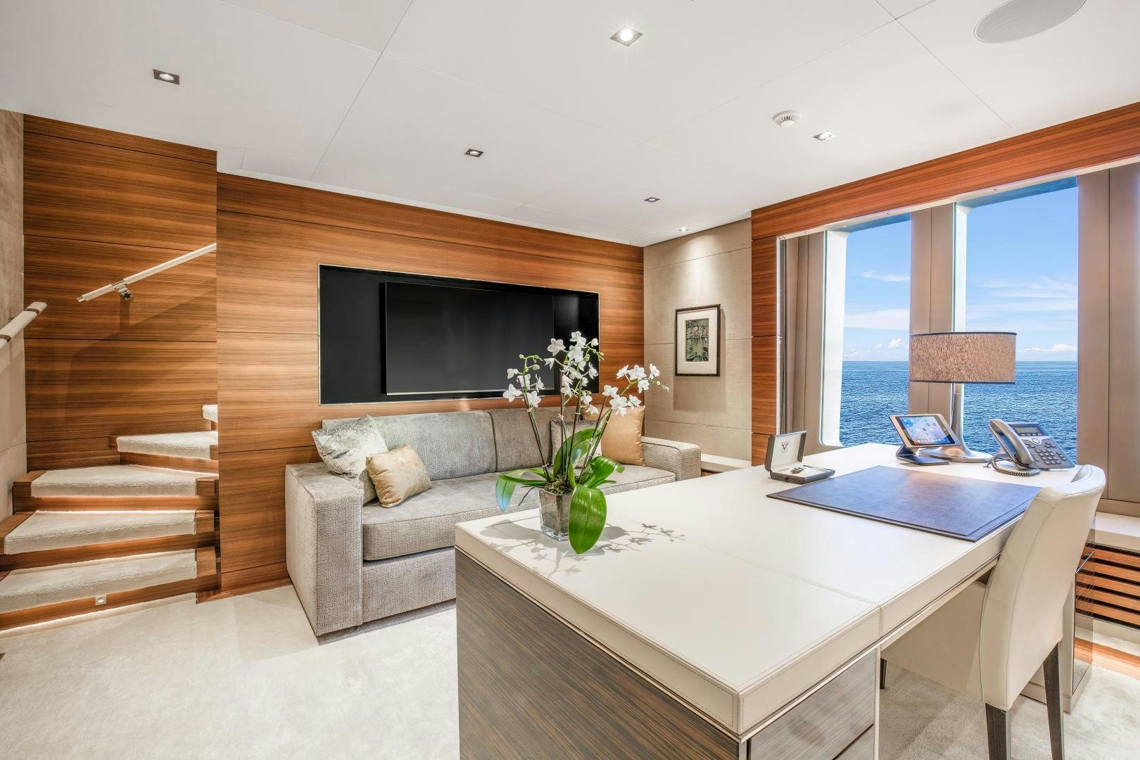 a modern looking living room with a large white table and a large window aboard ATOMIC Yacht for Sale