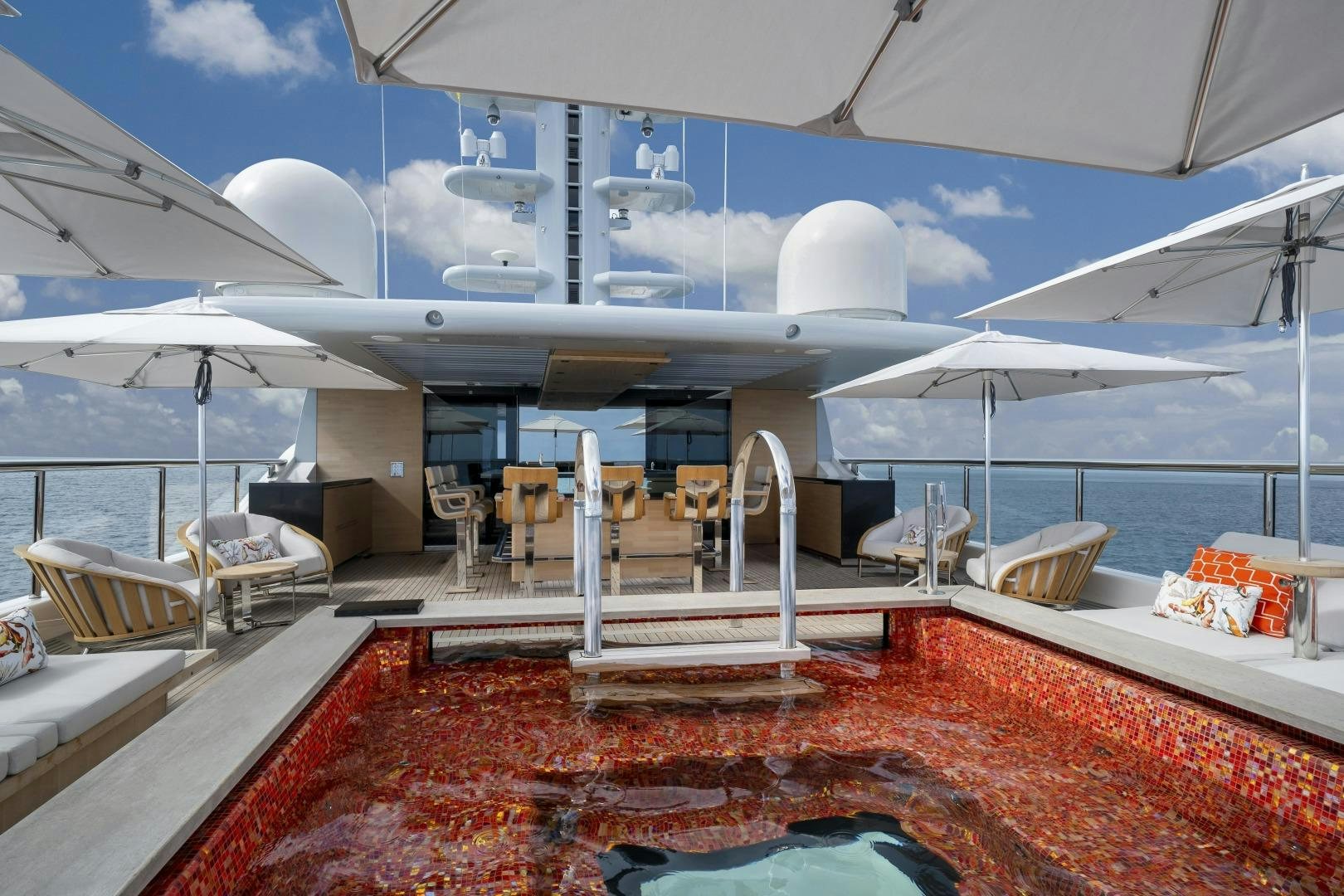 a large white tent with a red rug and a table and chairs aboard ATOMIC Yacht for Sale