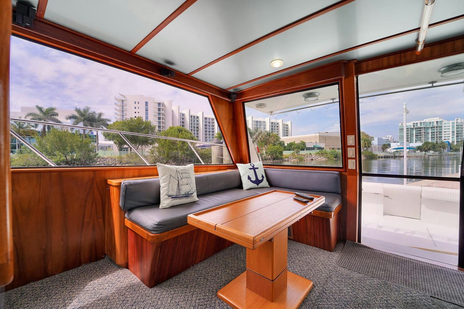 a couch and coffee table in a room with a view of a city aboard STEALIN TIME Yacht for Sale