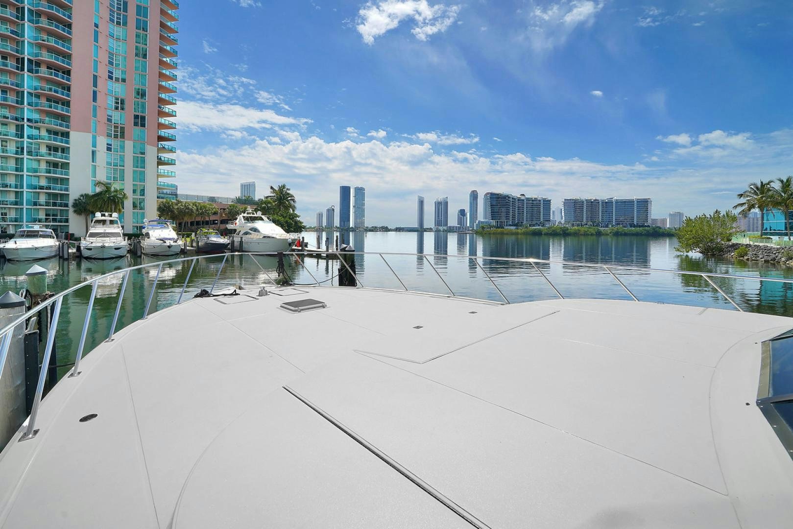 a white sandy beach with boats and buildings in the background aboard STEALIN TIME Yacht for Sale