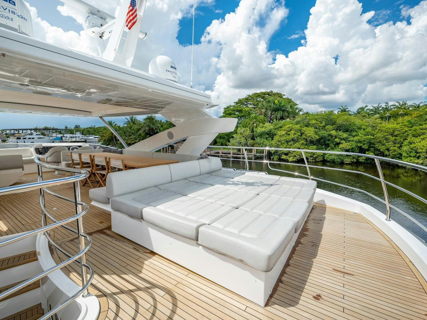 a deck with a white roof and a white building with a flag on it aboard TATIS Yacht for Sale