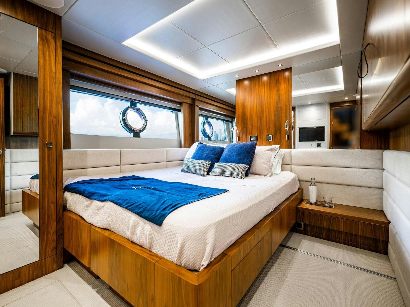 a bedroom with a bed and a wood door aboard TATIS Yacht for Sale